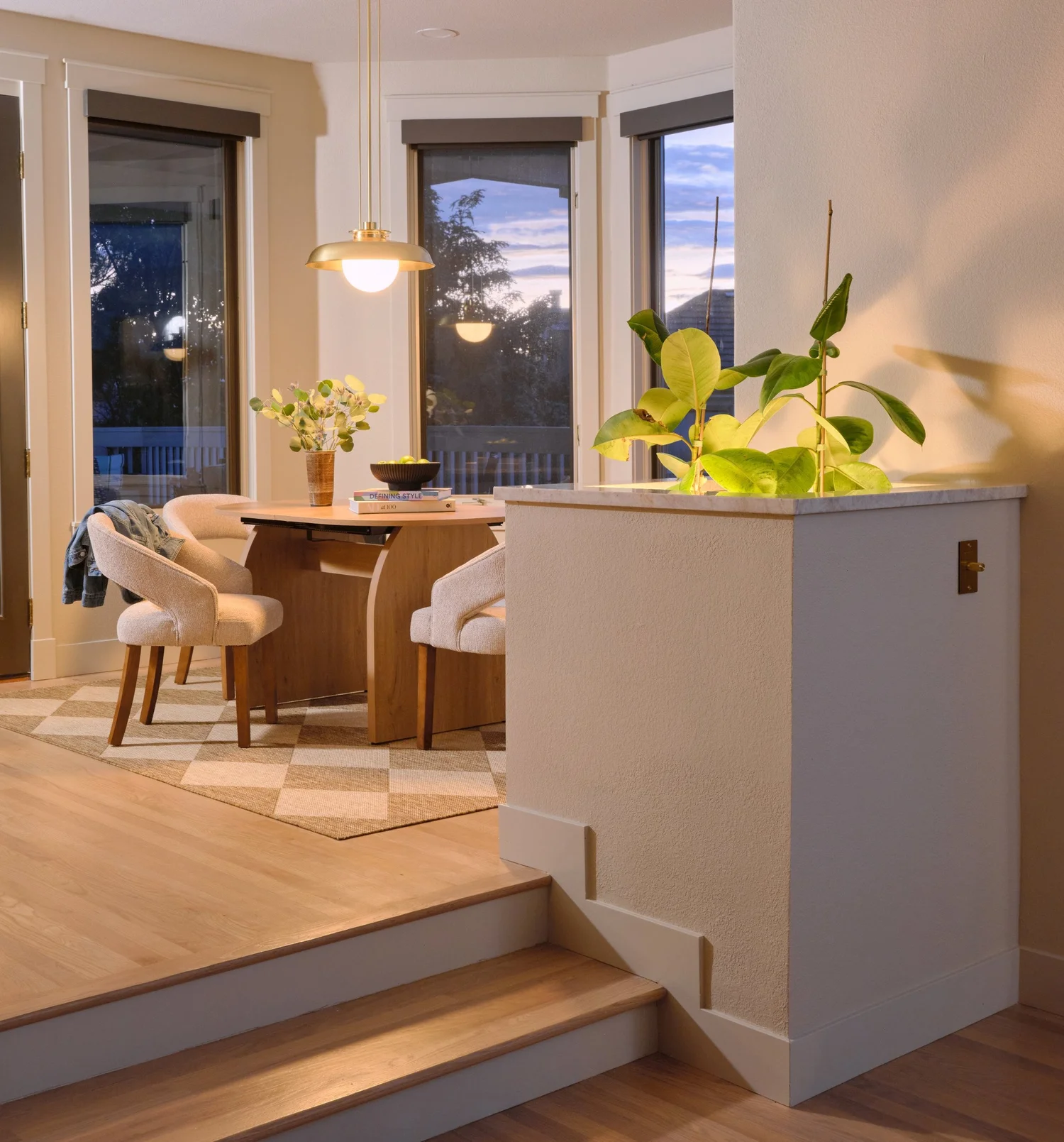 Built-in planter at the steps with an uplit fiddle leaf and a brass toggle