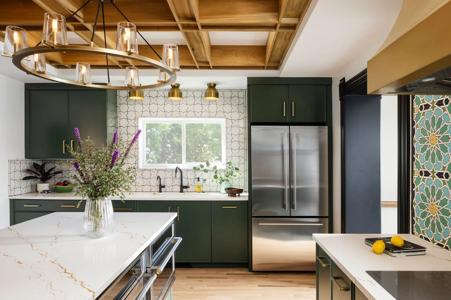 Kitchen after renovation with brass range hood and coffered ceiling