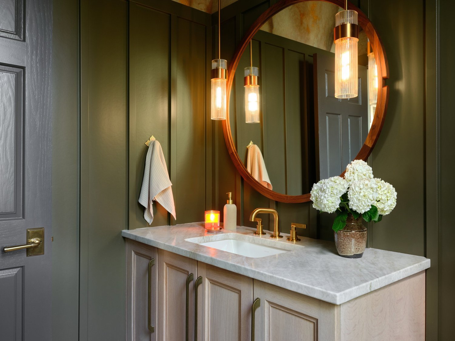 Brushed brass faucet on Taj Mahal quartzite with the Iron Ore door