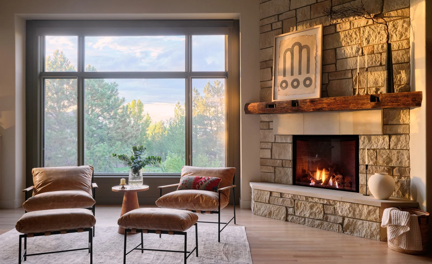 Living room at dusk with the stacked stone fireplace and the picture window