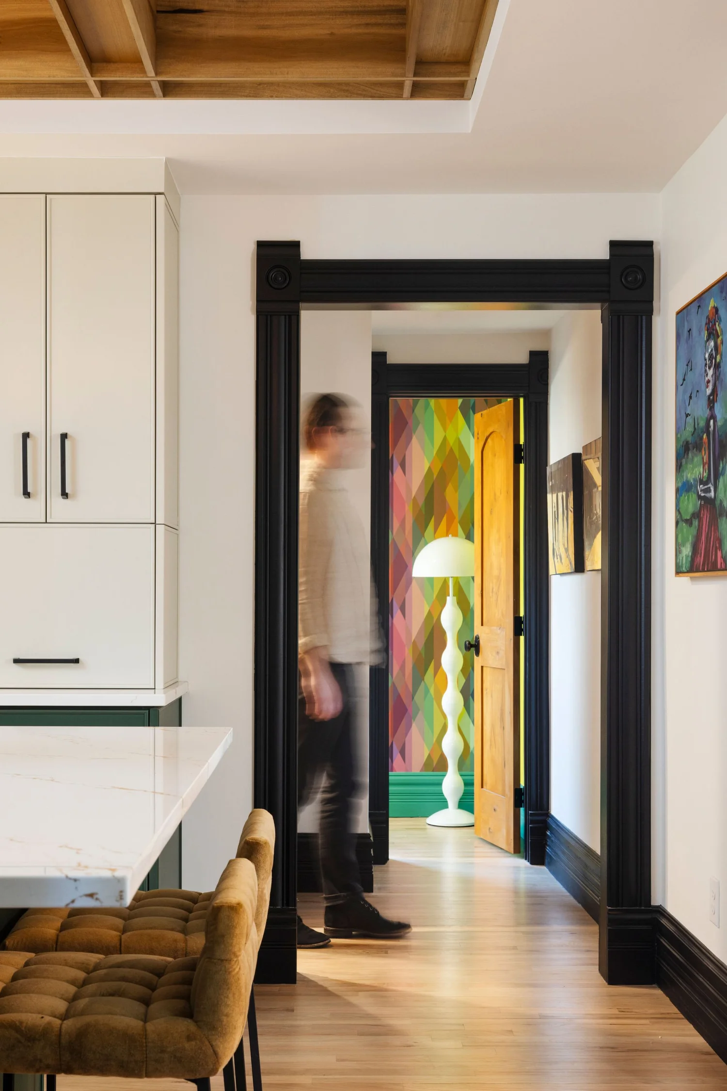 Looking from the kitchen through the black cased doorway to the harlequin hall