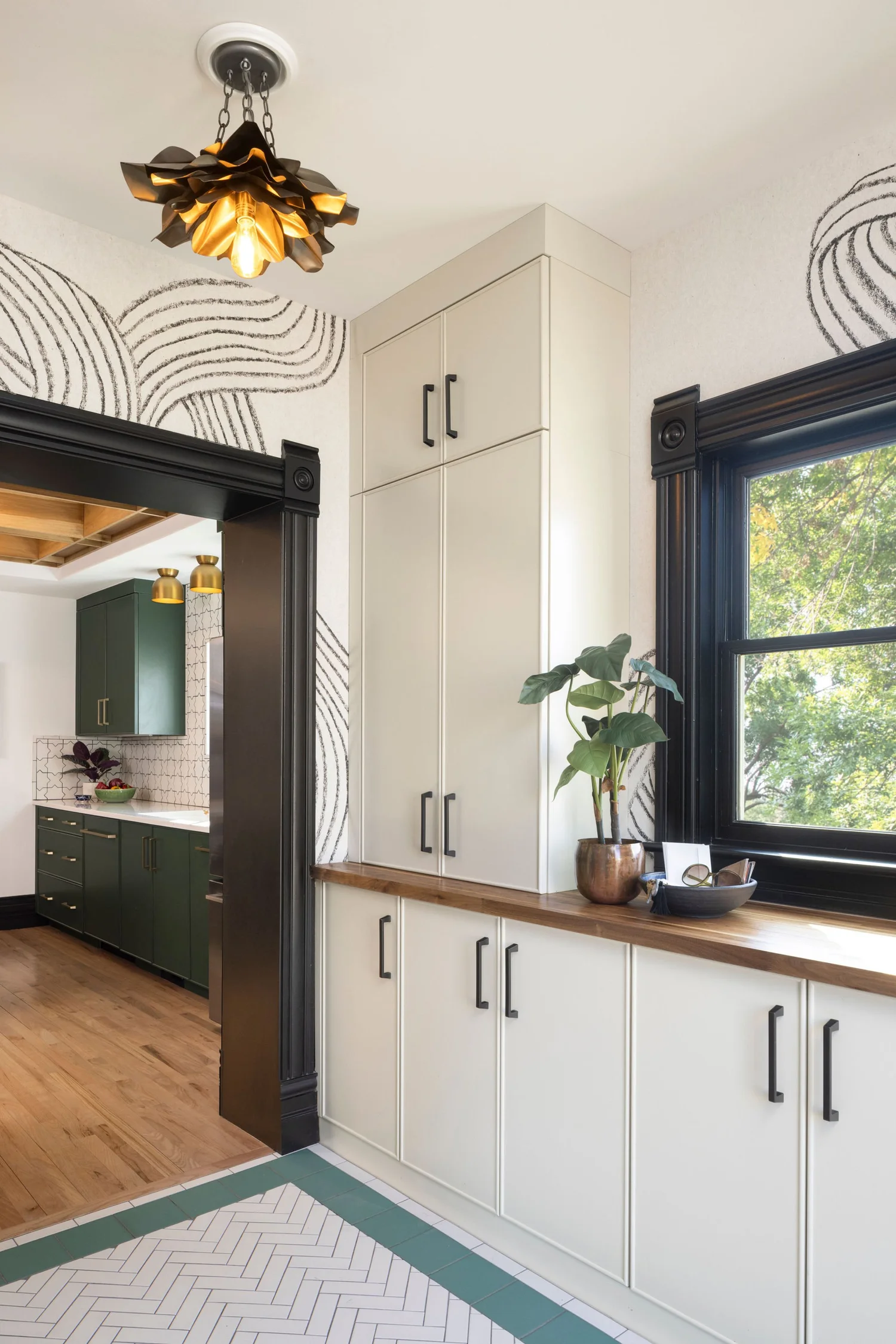 Mudroom bench, hooks and storage beneath the black cased window