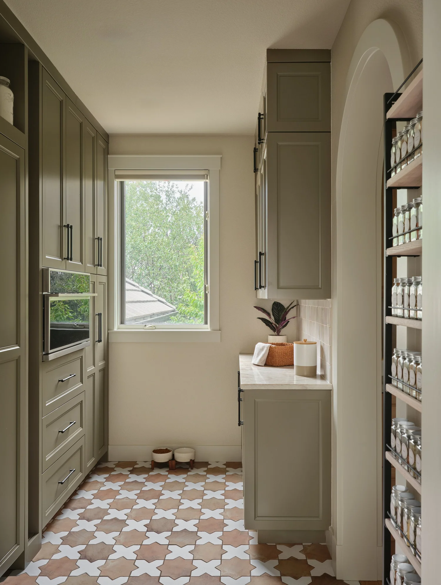 Pantry window wall with painted cabinetry, the speed oven and star and cross tile