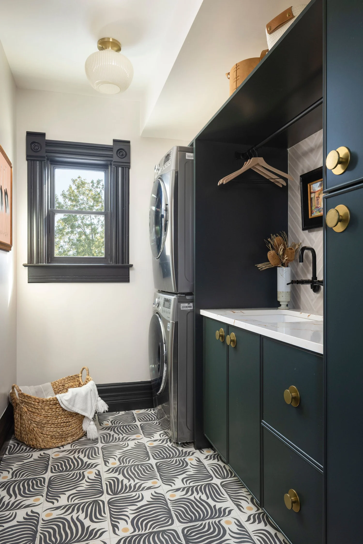 Laundry room after renovation with green cabinetry and patterned floor tile