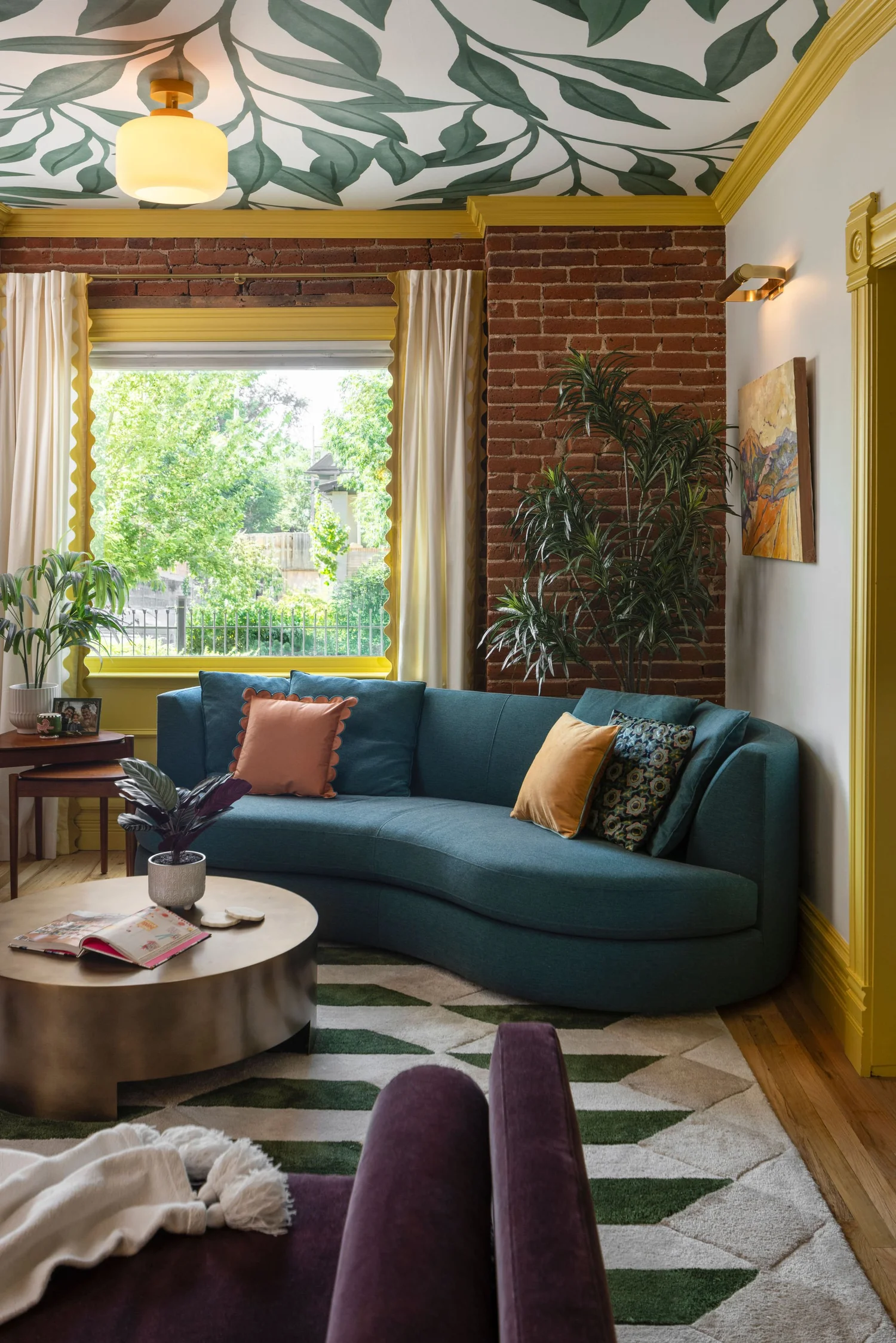 Teal sofa and brick wall with the purple daybed in the foreground