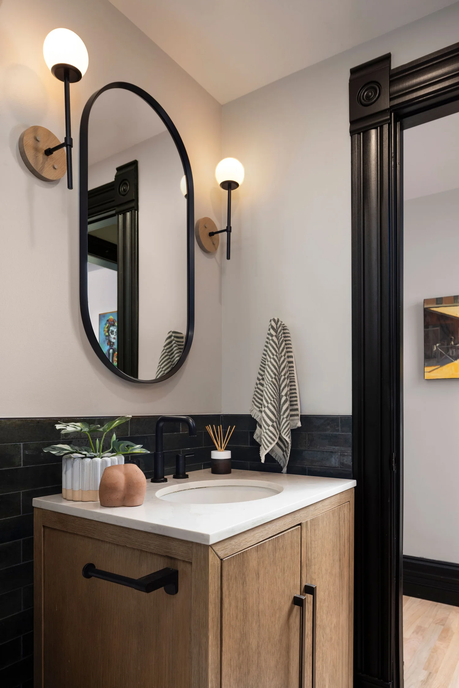 Bath one vanity and mirror against the olive wainscot tile