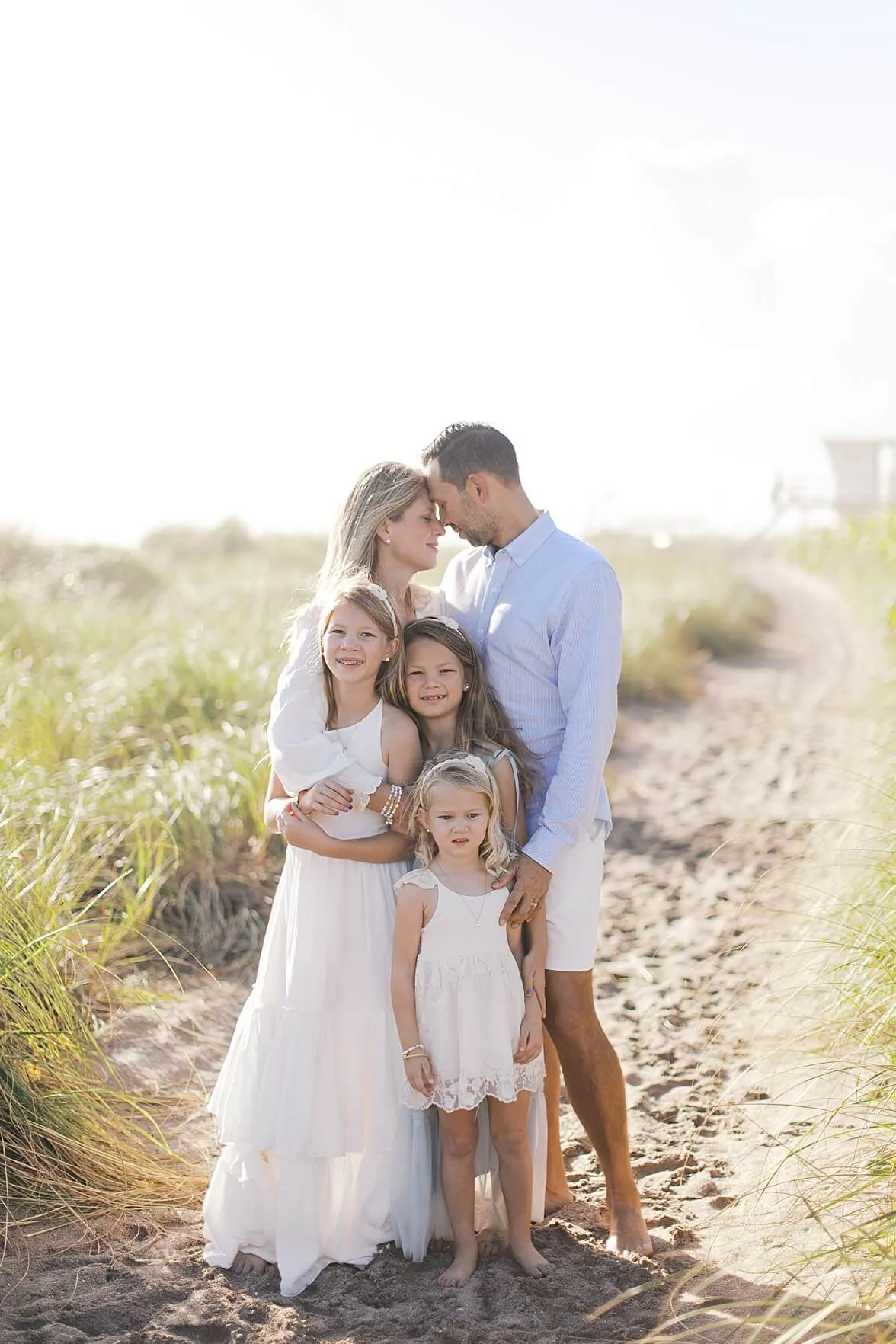 family wrapped up in mom and dads arms on the beach