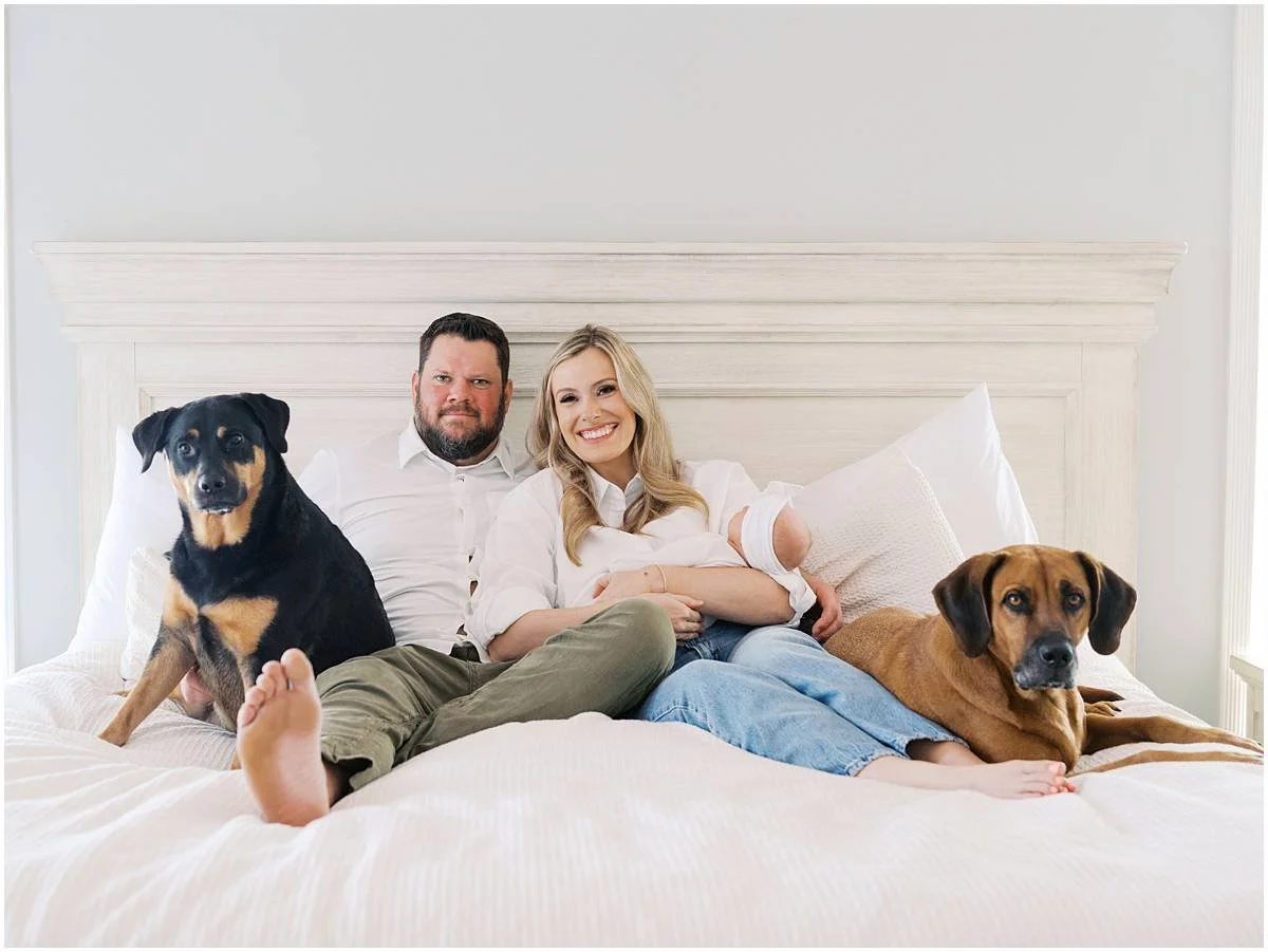 mom, dad, baby and dogs pose for photo at newborn session