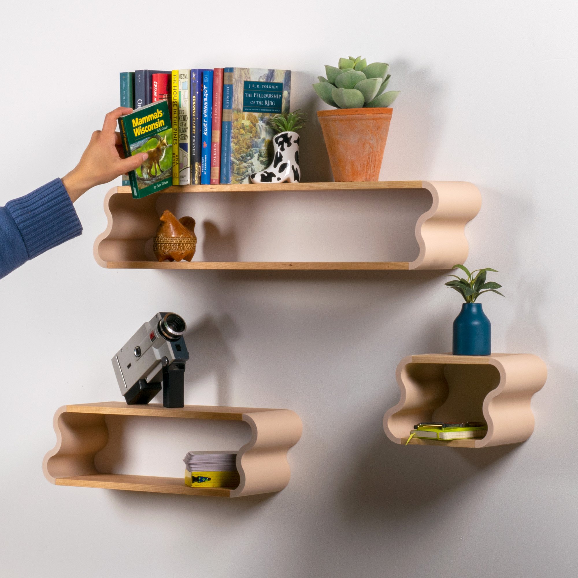In use photo of cherry and pastel pink Squiggle Floating Shelves | Pastel Accented Cherry and Ash Hardwood Shelving | Modular Display & Storage | Floating Shelving | Wall Shelf