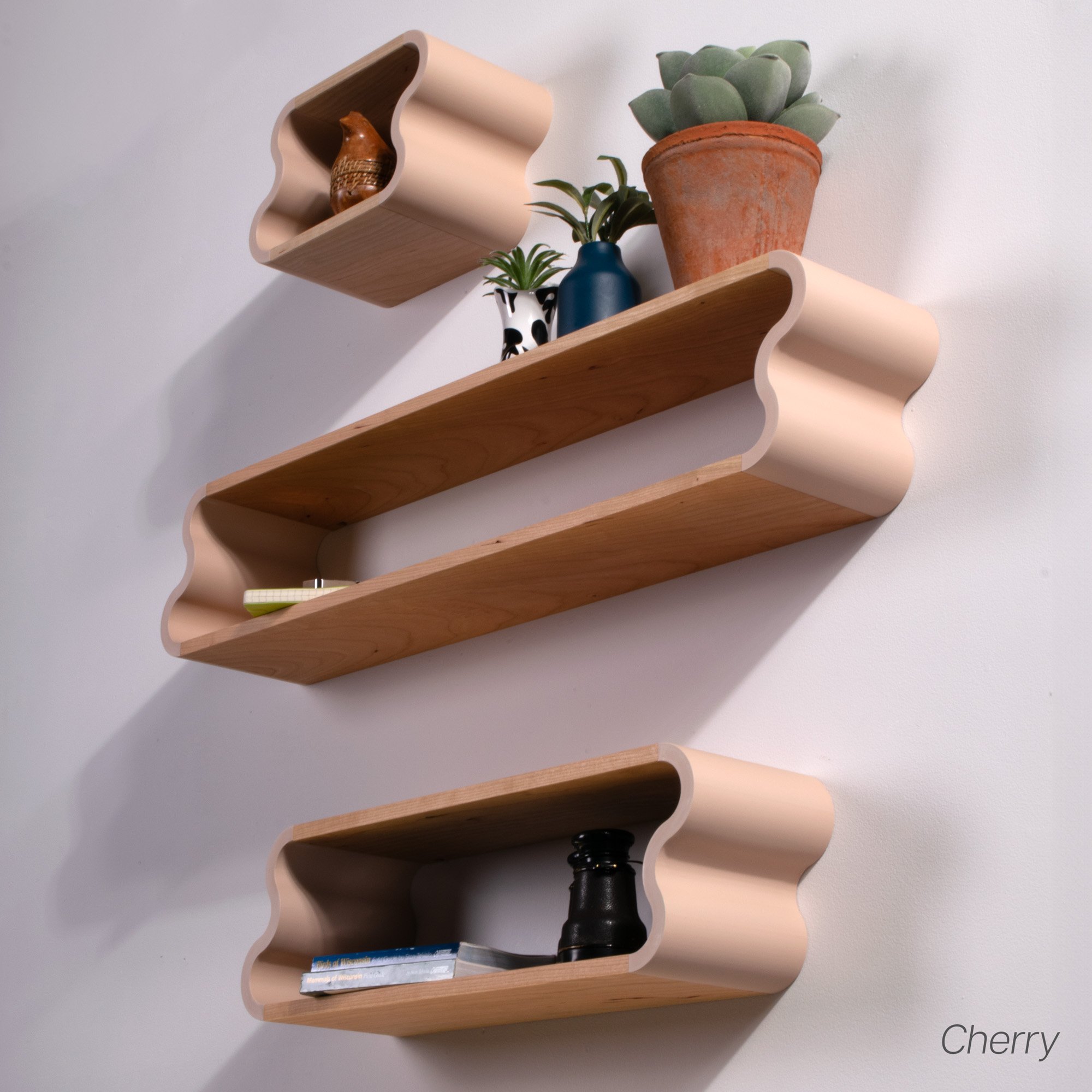 In use photo of cherry and pastel pink Squiggle Floating Shelves | Pastel Accented Cherry and Ash Hardwood Shelving | Modular Display & Storage | Floating Shelving | Wall Shelf