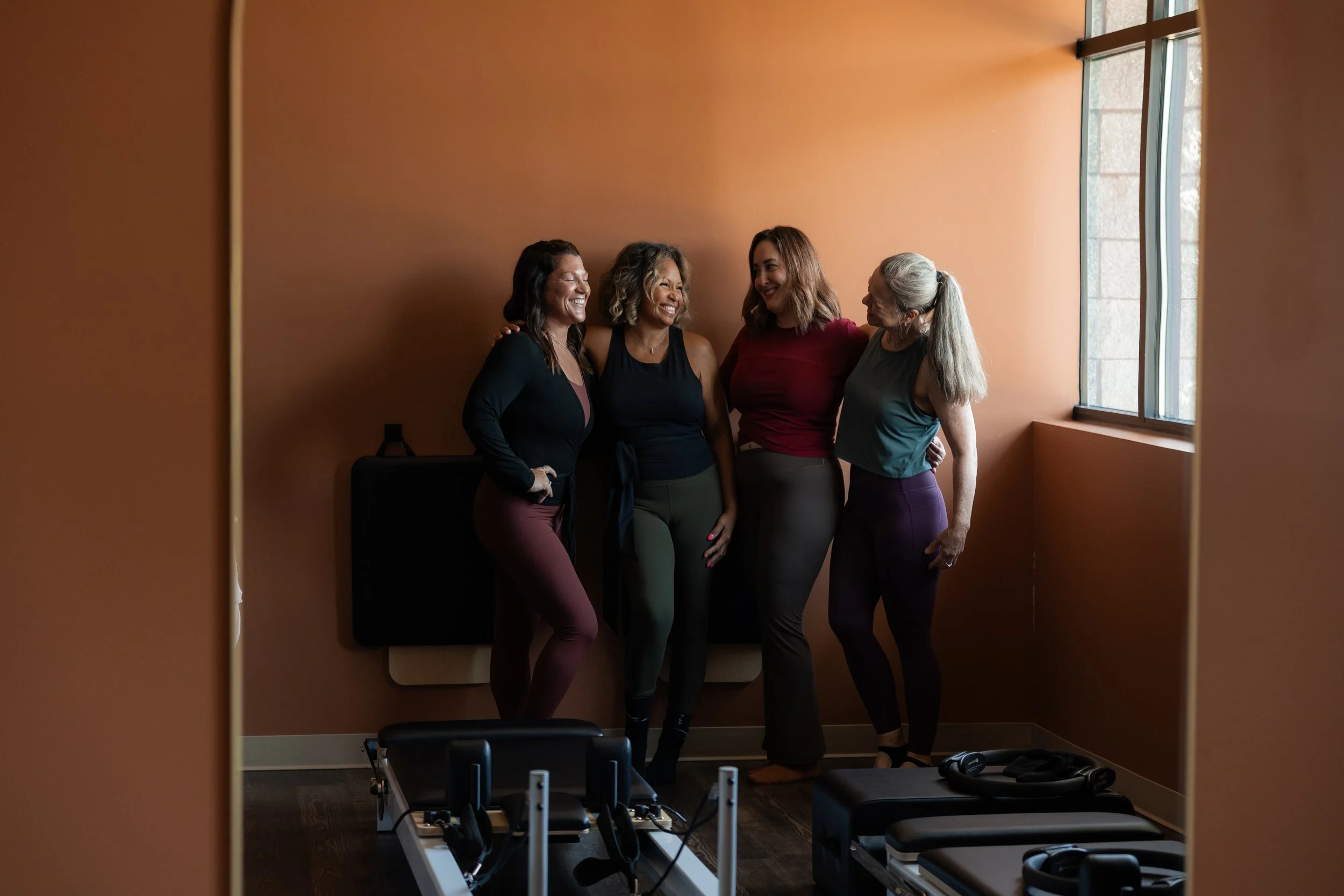 Our Founder, Natalie Hayden, smiling with our VIP members in our Reformer Pilates studio in Norton Shores, Michigan