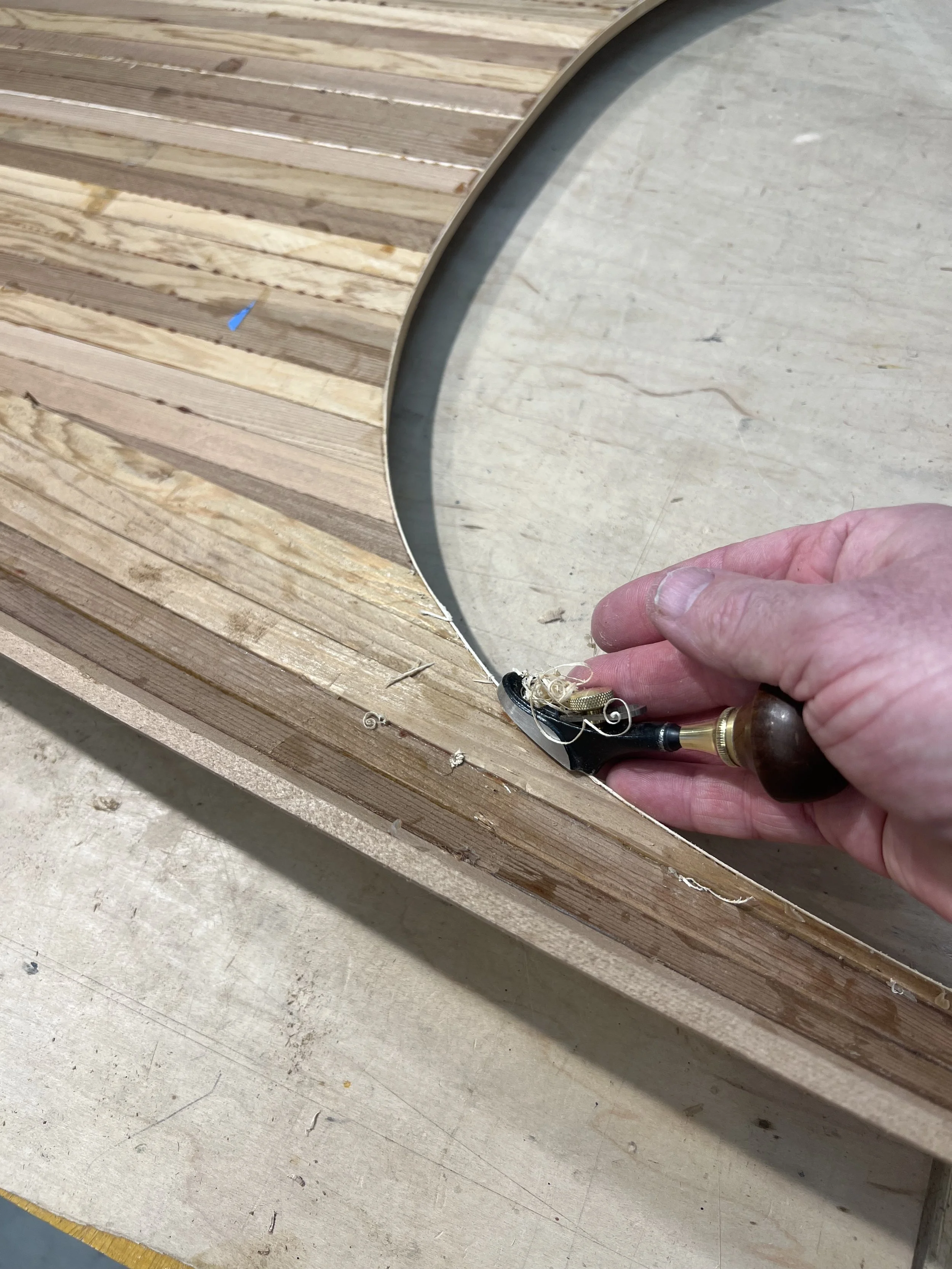 cleaning up cockpit opening sitka spruce accent with a flat luthier palm plane.jpeg