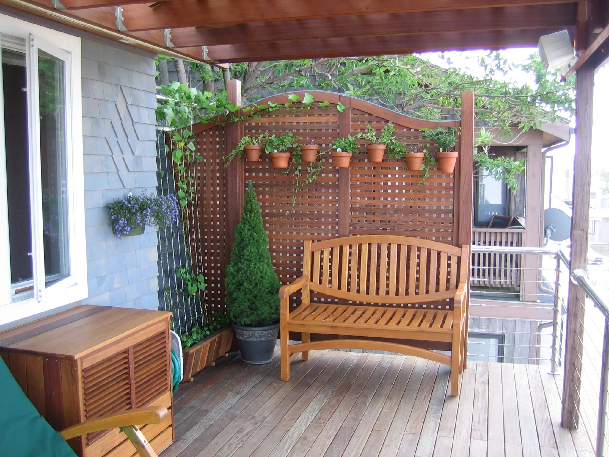 Ipe A/C cover with louvered venting. Diamond cedar pattern by Kris White. Lead covered posts and top of serpentine privacy screen. 