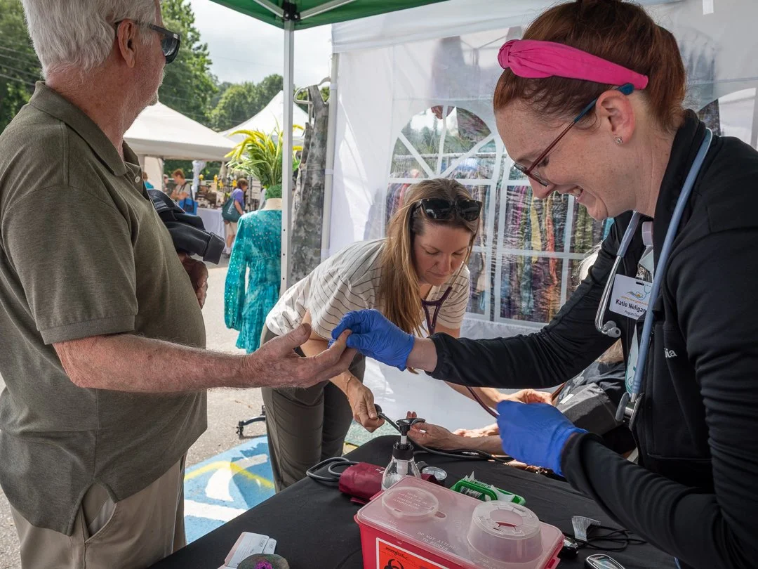  NeighborCare Program Director Katie Neligan, RN, and Kasia Abel, RN (known by their patients as Nurse Katie and Nurse Kasia) perform free blood pressure and blood sugar screenings at the Sourwood Festival in downtown Black Mountain, August 2025. Nei