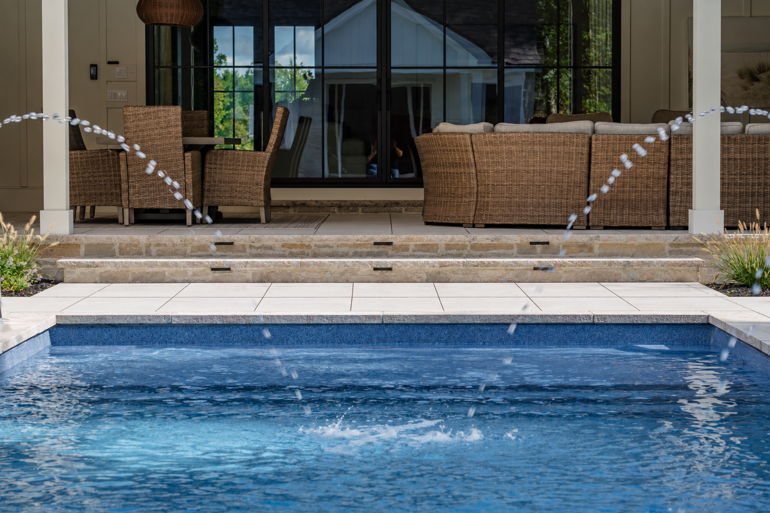 A modern pool featuring GeoCeramica Urban Pearle with culture stone accents, a fountain and outdoor entertaining spaces