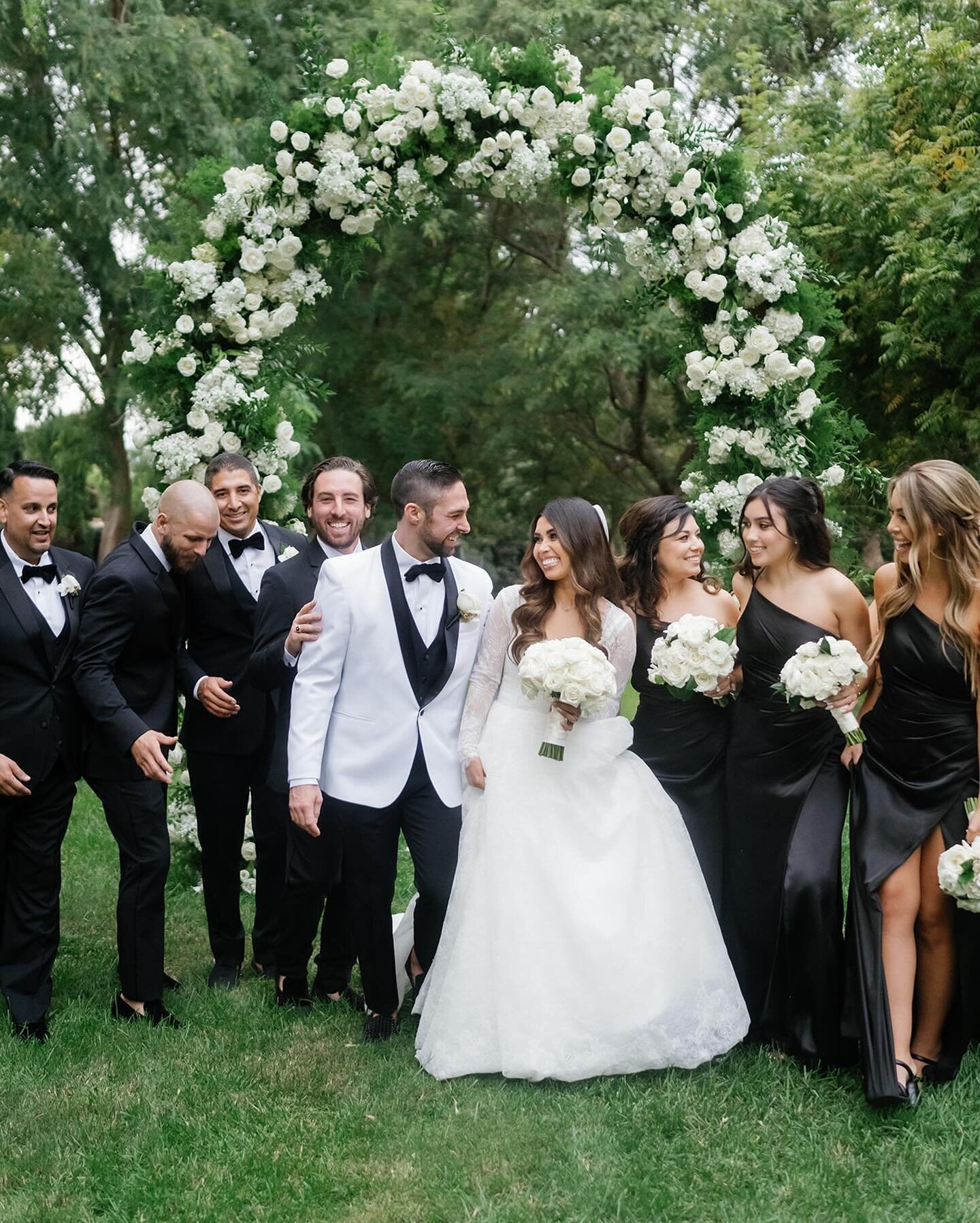 Classic &amp; Chic for A + J ✨
Photo: @aliciaminkphoto 
Florals: @squarerootdesigns 
#weddingceremony #ceremonyarch #blackbridesmaiddresses #whitetuxedo #laweddingplanner