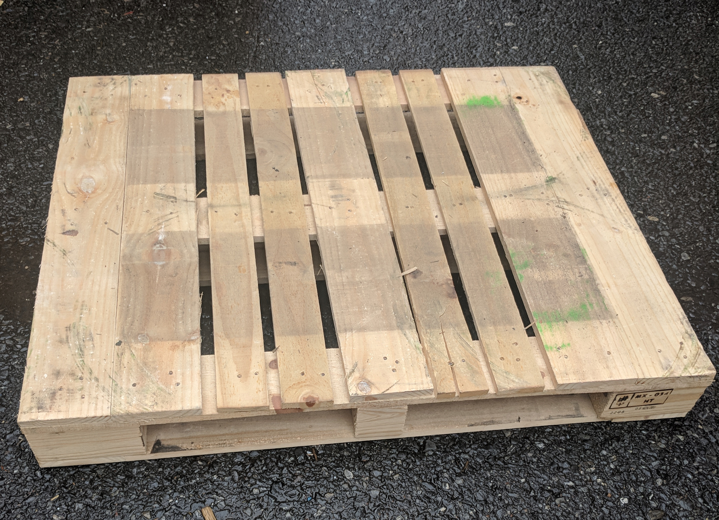 Wooden pallet on asphalt ground.