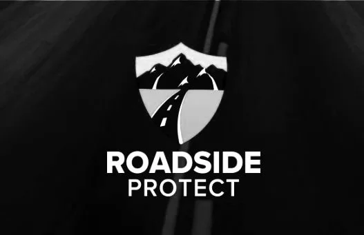 A logo with a shield featuring a mountain, a road, and trees, with the words 'Roadside Protect' below.