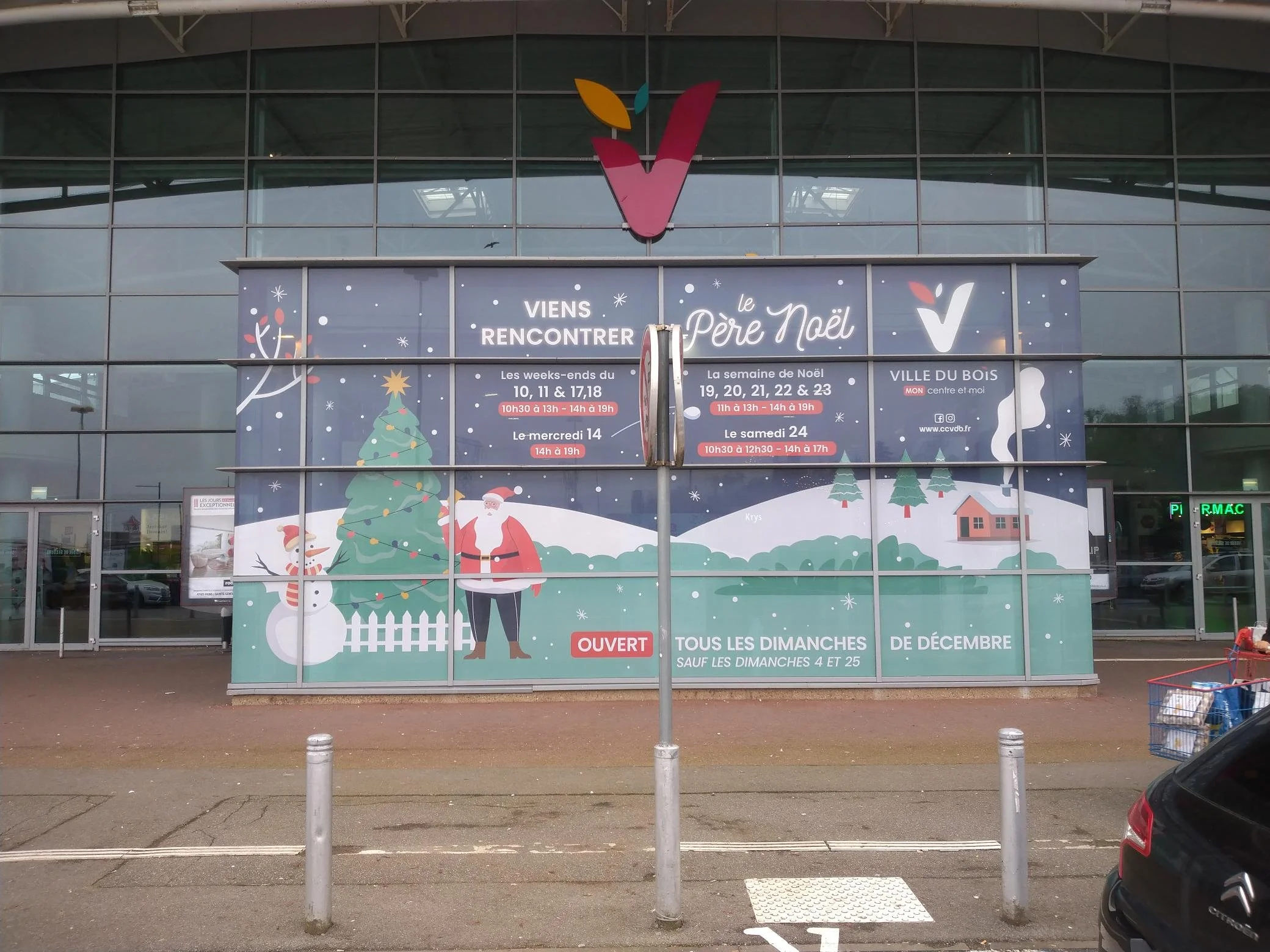 Affiche de Noël avec un sapin, un bonhomme de neige, un Père Noël et une maison dans un paysage enneigé, annonçant les horaires d'ouverture pour la rencontre de Noël à Ville du Bois. 