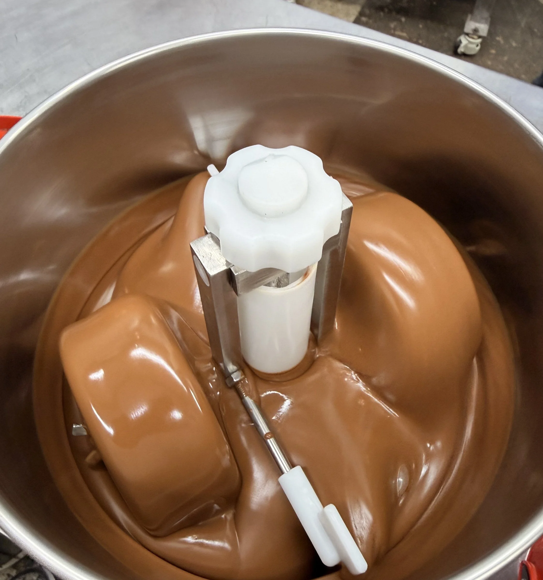 Milk chocolate being refined in a stone grinder
