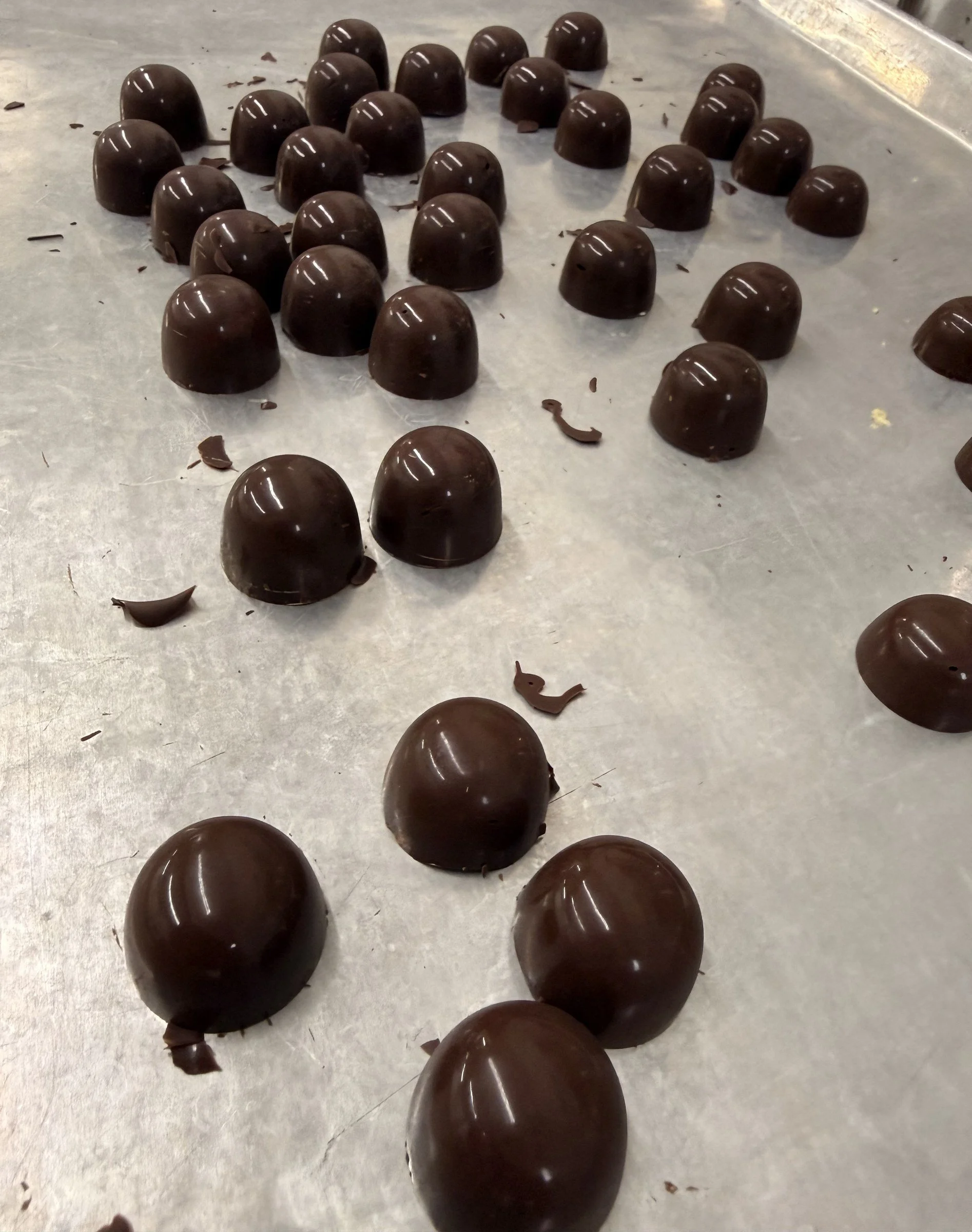 Dark chocolate bonbon domes on a tray
