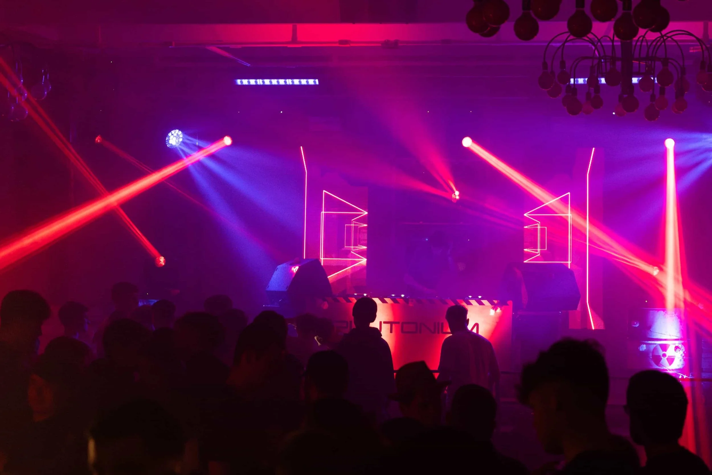 Publikumssilhouetten bei einer Abendveranstaltung in Österreich mit roter Lasershow und Bühnenbeleuchtung