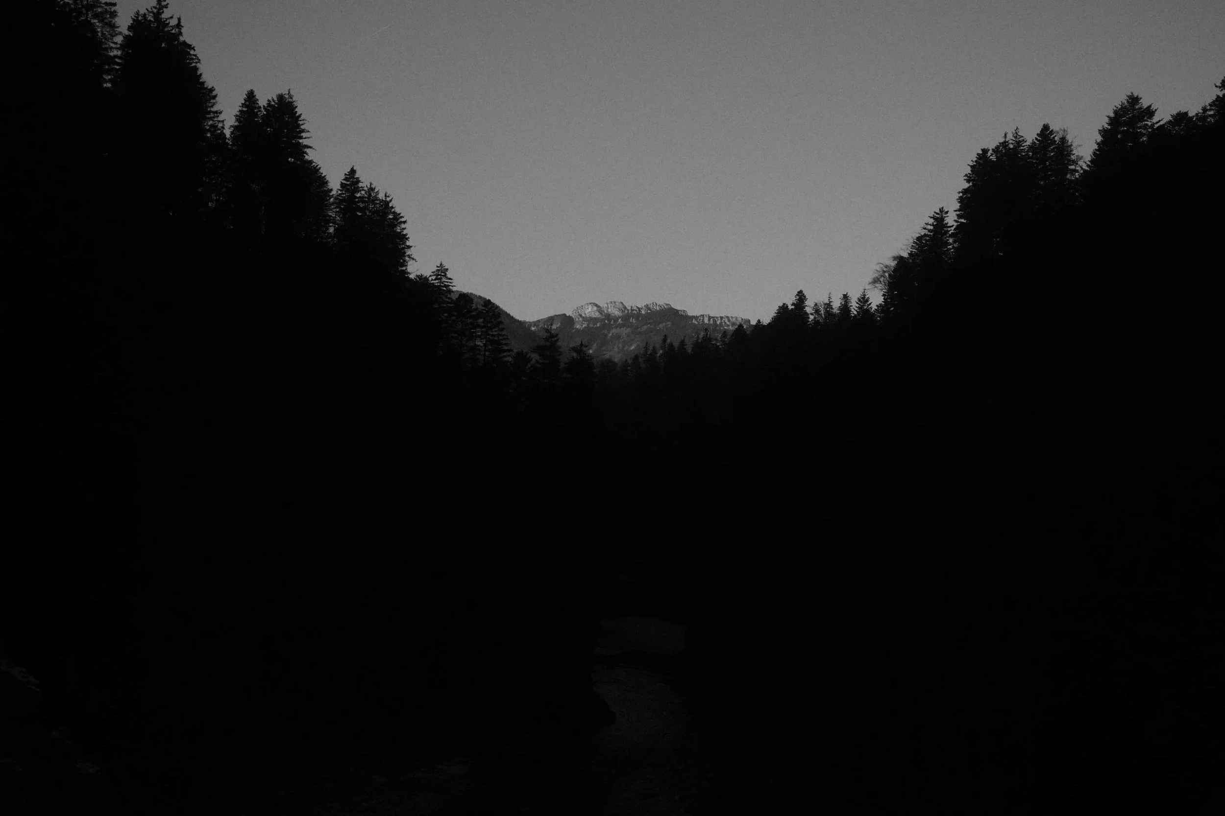 Bergtal mit Fluss in der Dämmerung – atmosphärische Schwarz-Weiß Fotografie von Markus Mittermayer