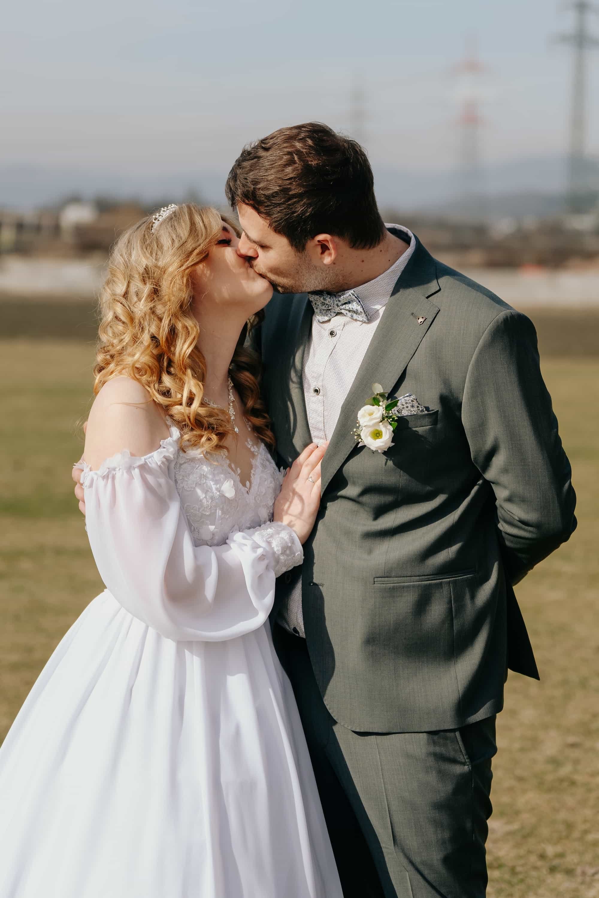 Brautpaar beim romantischen Kuss beim Outdoor-Fotoshooting nach der Hochzeit in Niederösterreich