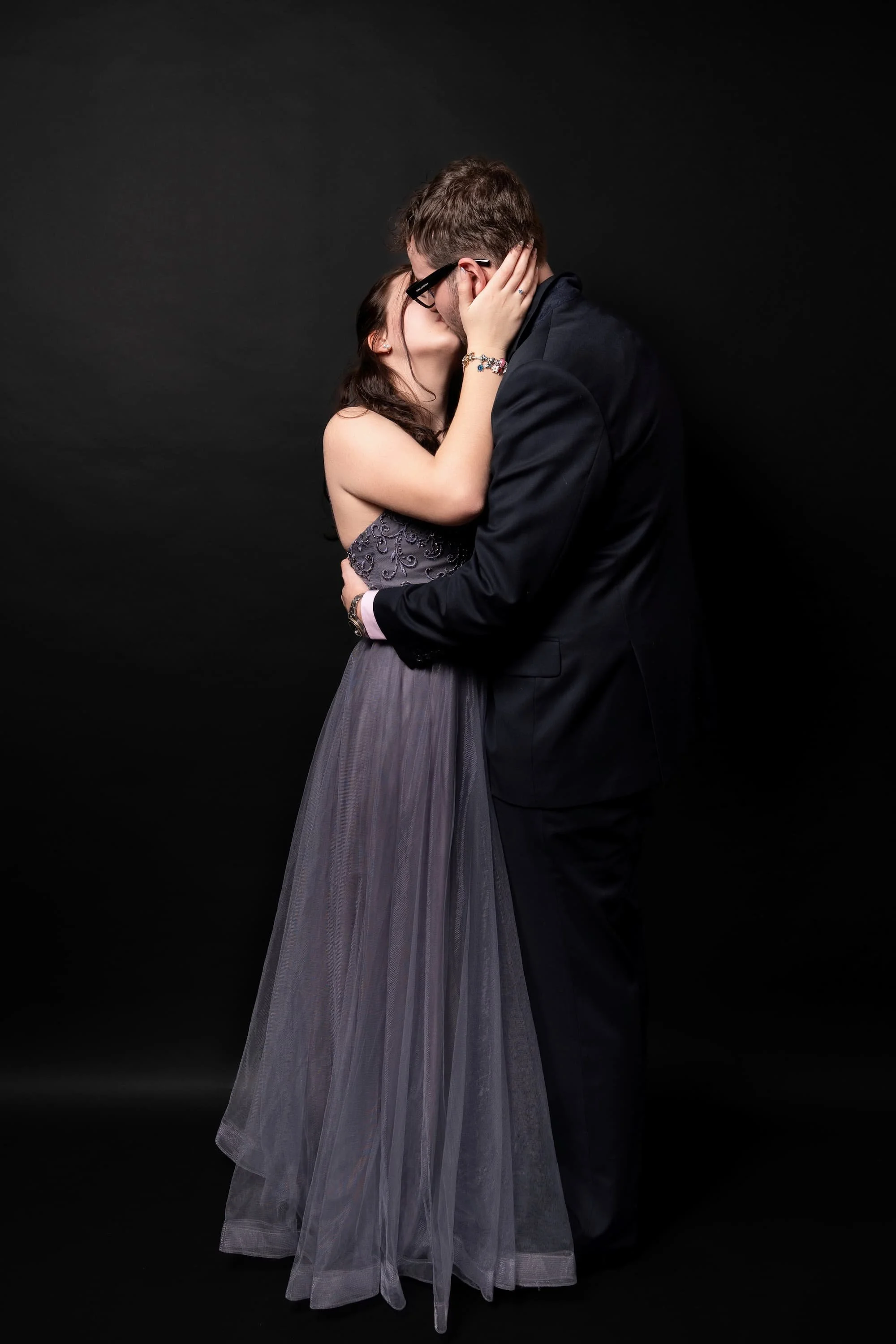 Nahaufnahme küssendes Paar-Portrait: Frau im grauen Tüll und Mann im Anzug, Schulball-Session