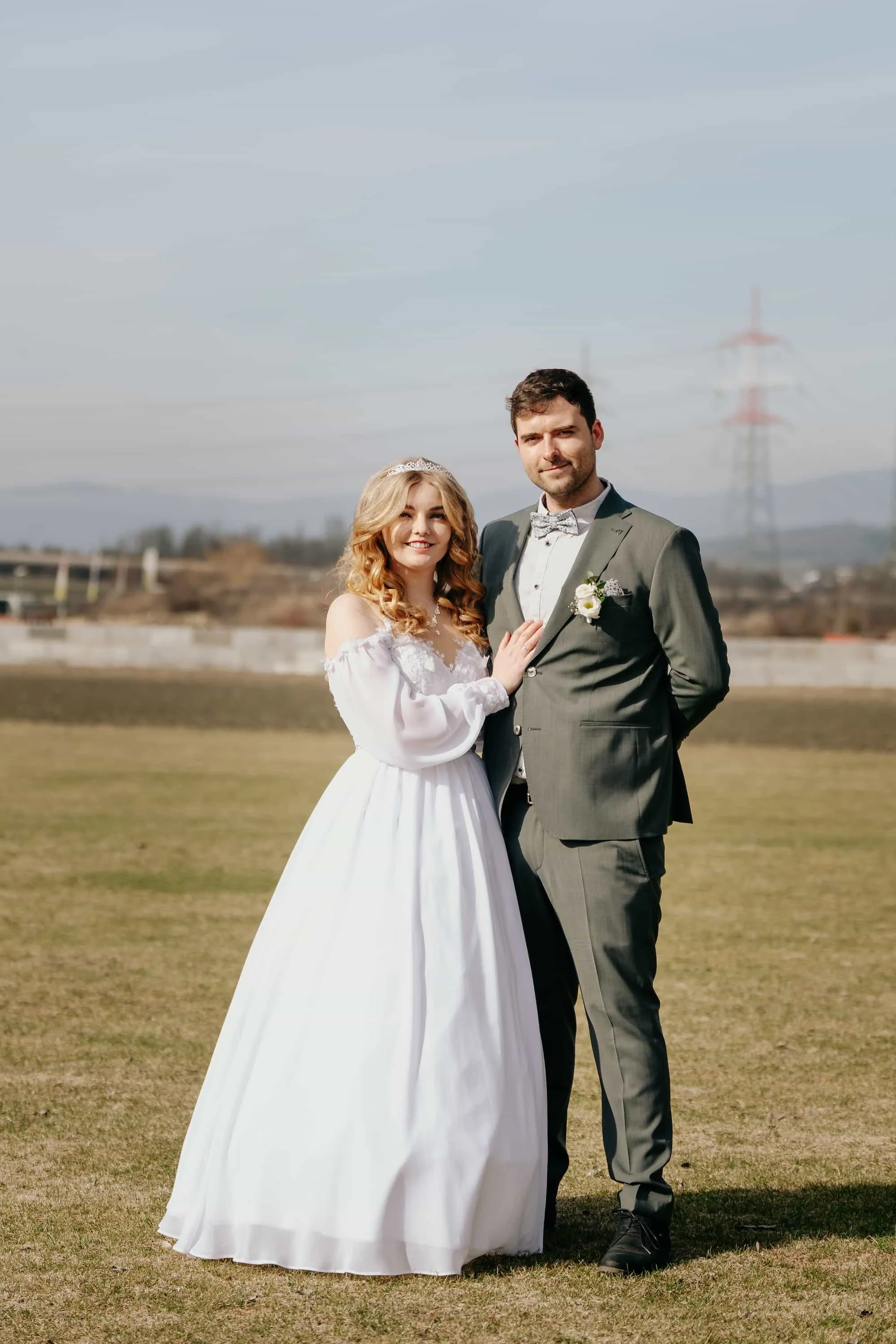 Brautpaar beim Outdoor-Shooting auf einer Wiese im Mostviertel, Braut im weißen Kleid mit Krone, Bräutigam im grauen Anzug
