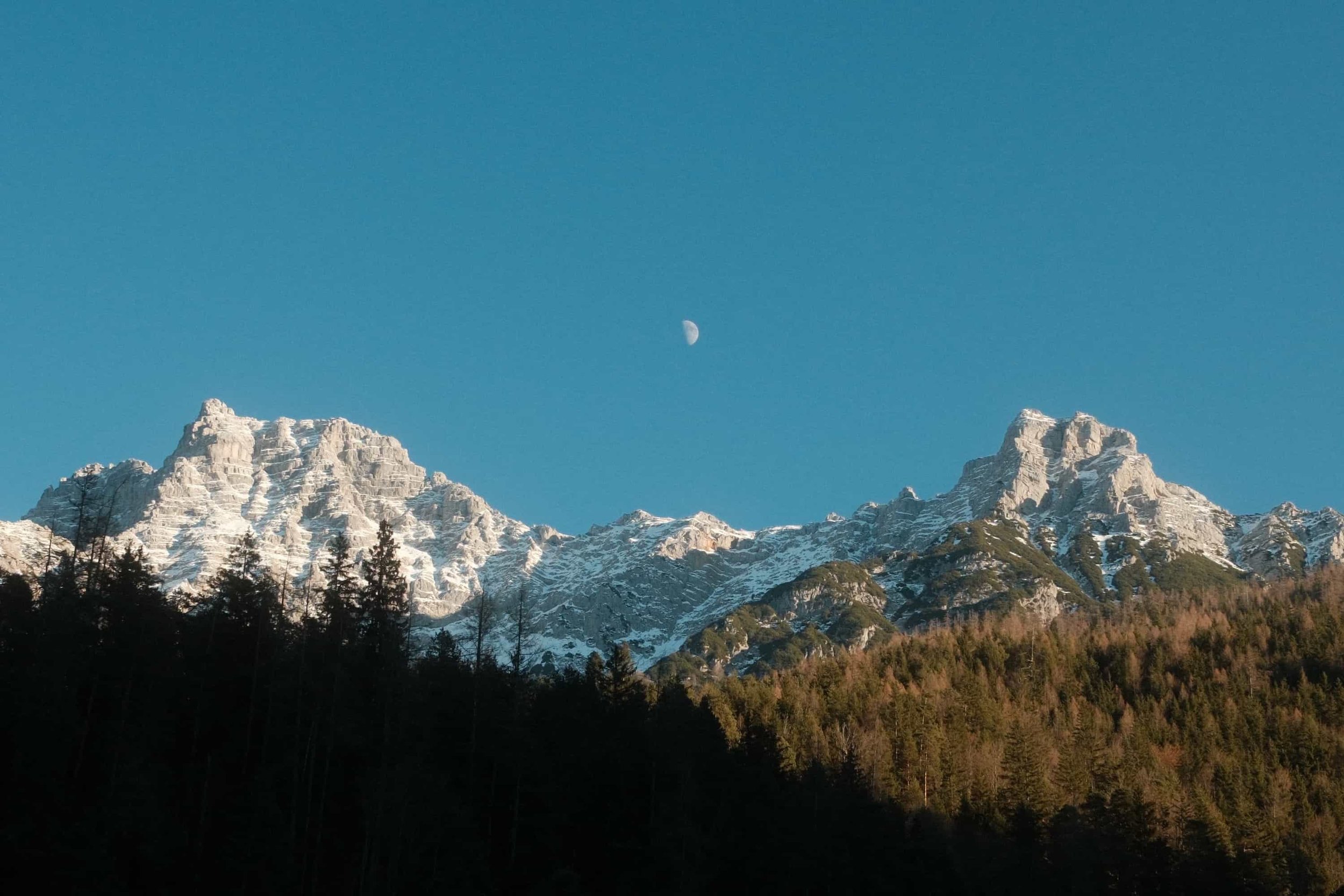 Schneebedeckte Alpengipfel mit Halbmond im Winterhimmel – Naturaufnahmen Österreich von Markus Mittermayer