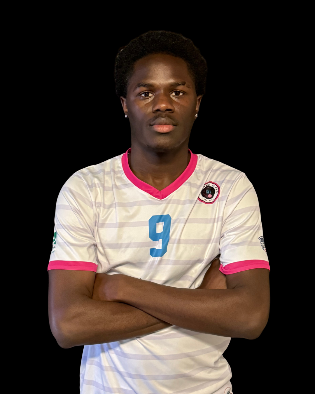 A young man in a black and blue sports jersey with the number 31, standing outdoors with a pink and gray cloudy background.