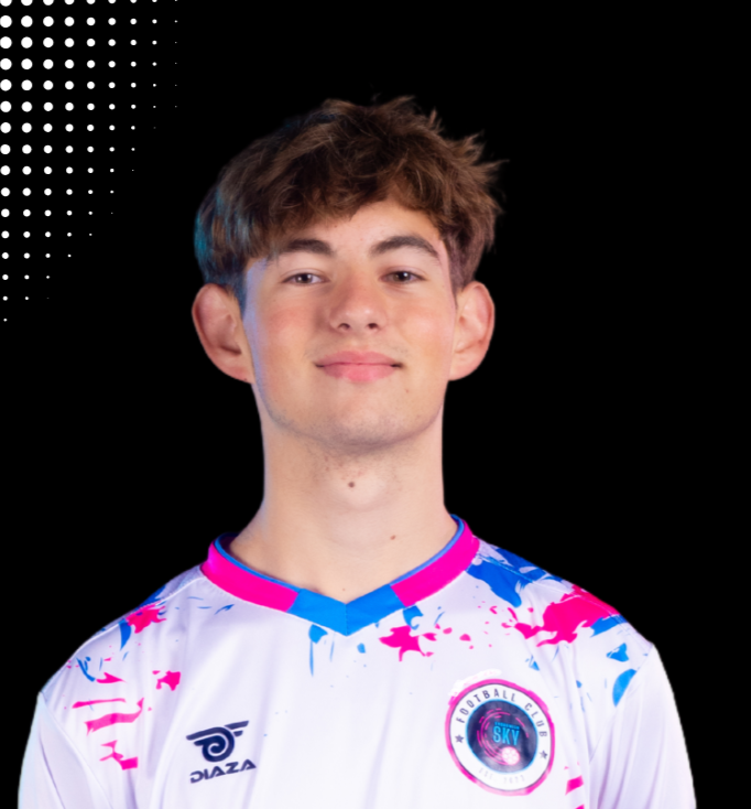 A young man with curly hair and a beard smiling, holding a soccer ball, wearing a black soccer jersey with pink