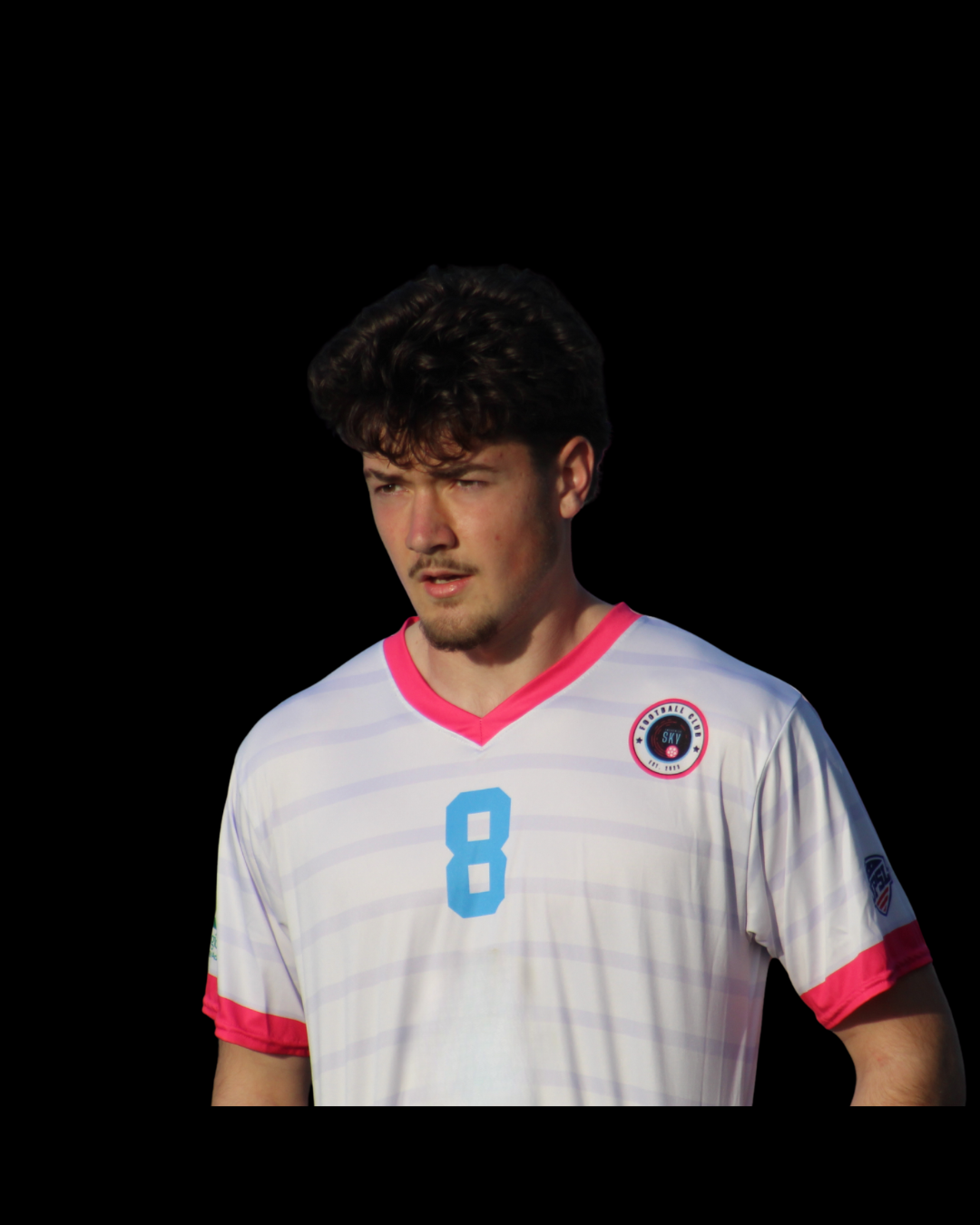 A male soccer player in a white jersey with red and blue accents, wearing number 13, with a focused expression on his face, against a smoky background.