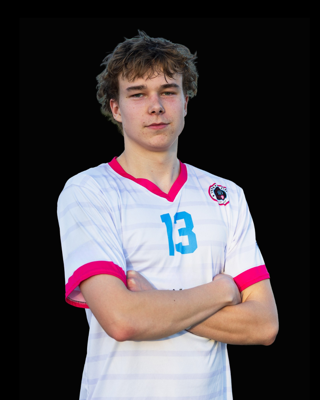 A young man in a white sports jersey with pink accents and the number 30, standing against a black background, crossing his arms.