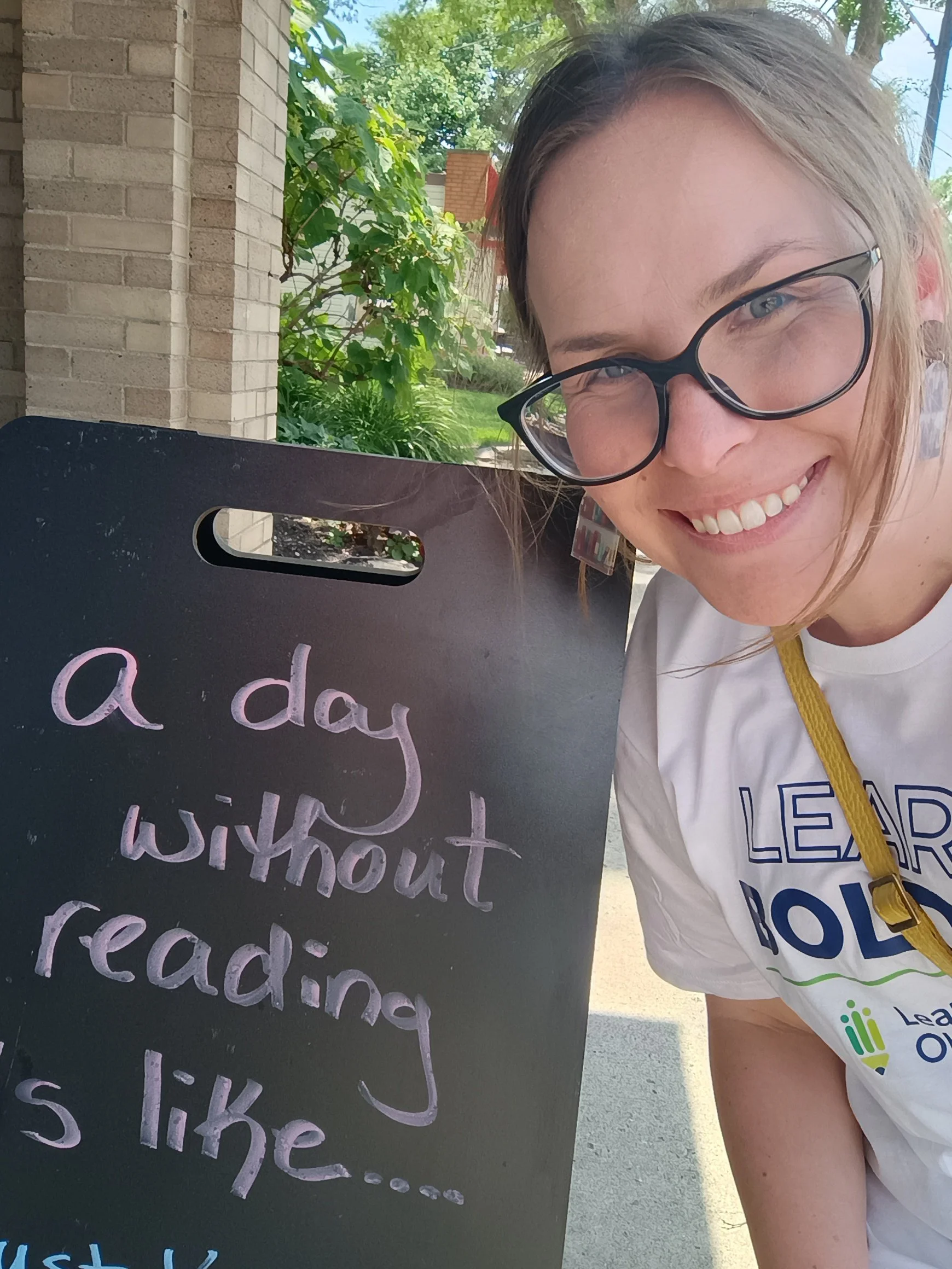 Photo of Rachel next to a sign that says "A day without reading is like..."