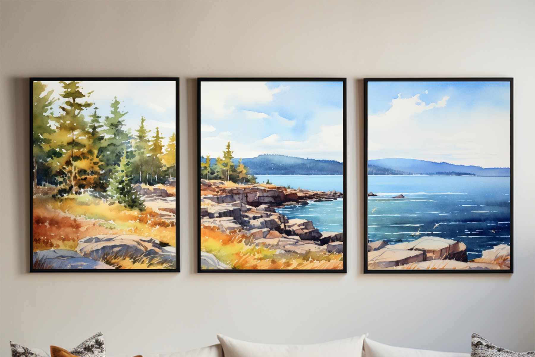 Framed Acadia coastal triptych wall art with watercolor-style pine trees, rocky shore, and blue ocean displayed above a neutral sofa.