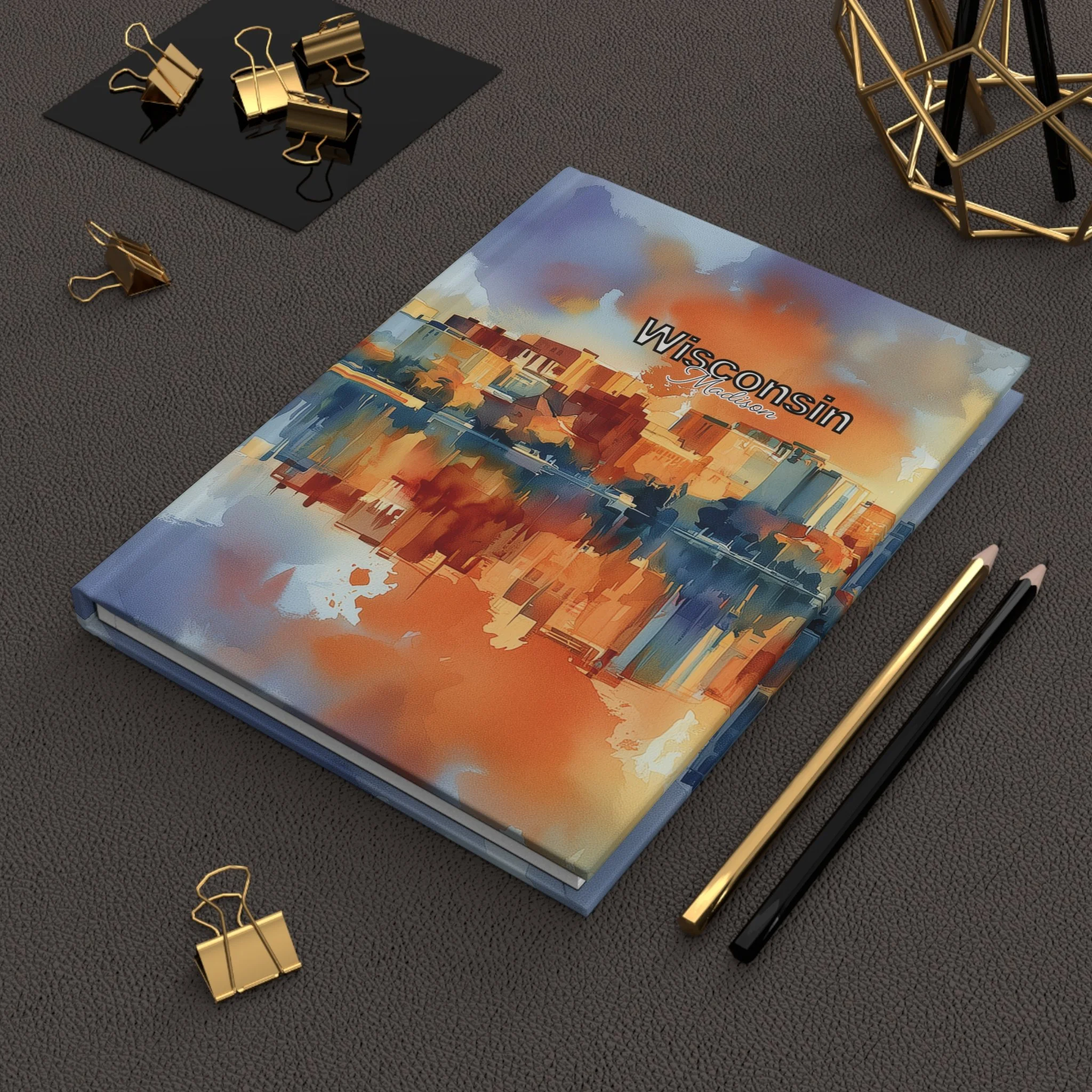 Wisconsin watercolor skyline journal on a dark desk with gold clips and pens