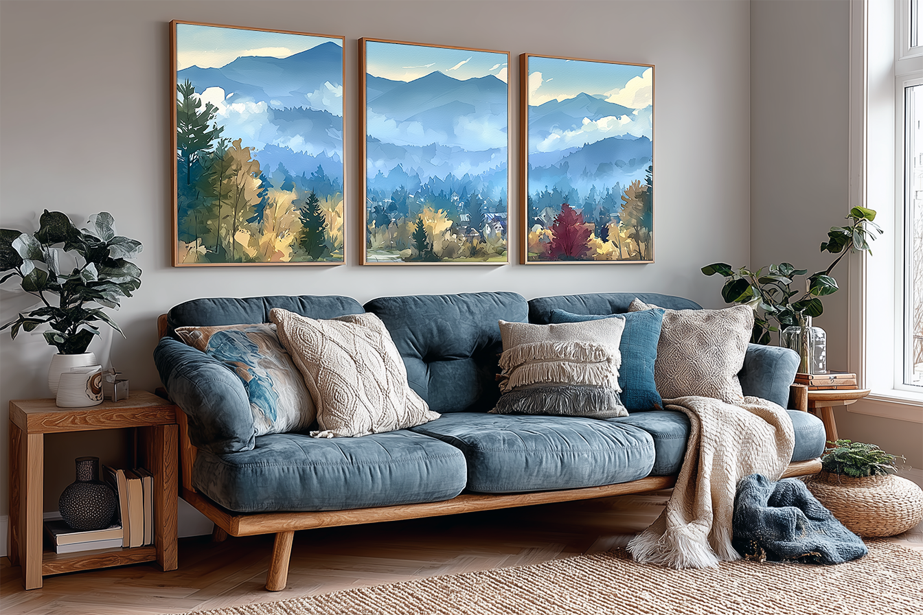 Three-panel Stowe Vermont village watercolor wall art above a blue sofa in a living room