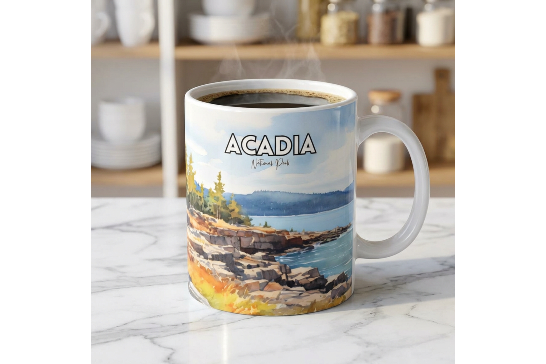White coffee mug featuring Acadia National Park watercolor artwork with rocky shoreline, blue water, evergreen trees, and bold park name text, filled with steaming coffee on a kitchen counter.