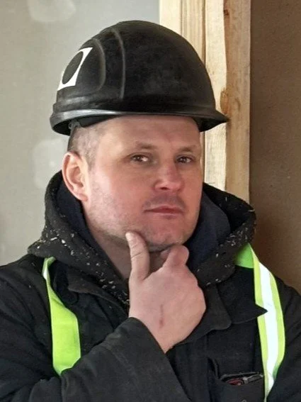 Icon of a person wearing a cap and a shirt with a mechanical logo, representing a mechanic or technician.