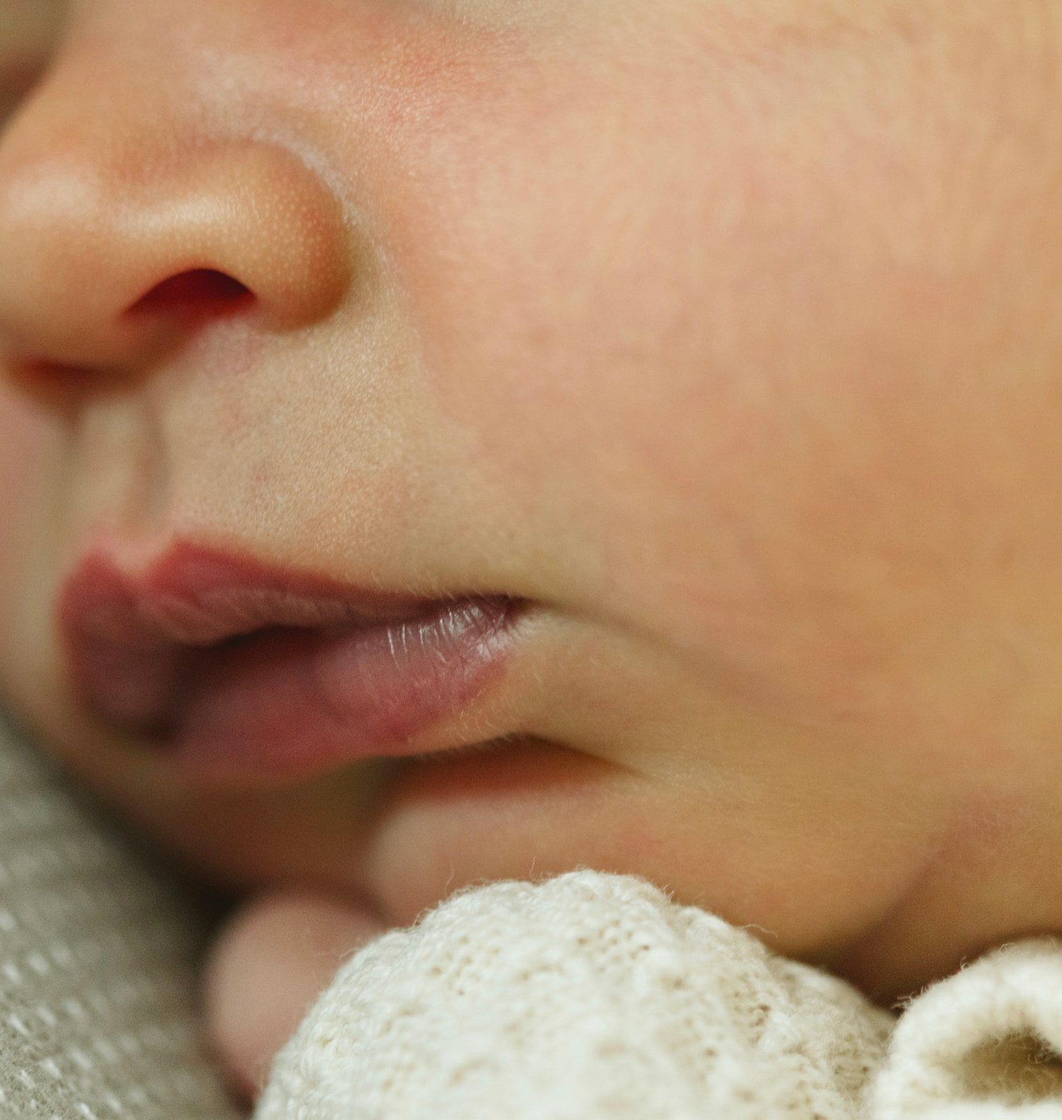 Newborn baby resting peacefully at home during an in-home family photography session in Destrehan, Louisiana.