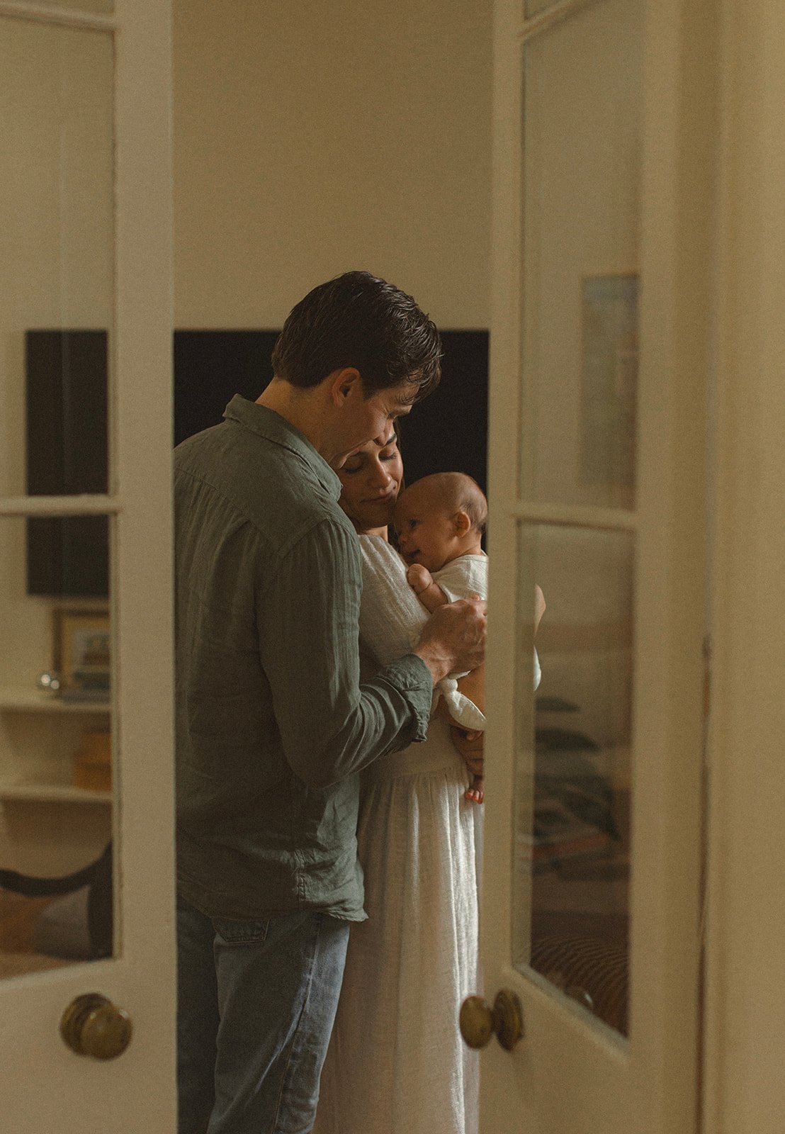 Parents walking through their home with their newborn during a relaxed New Orleans lifestyle photography session.
