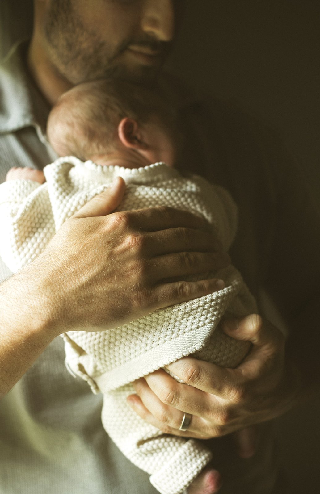 Parents holding their young child at home during a natural family photography session in Destrehan.