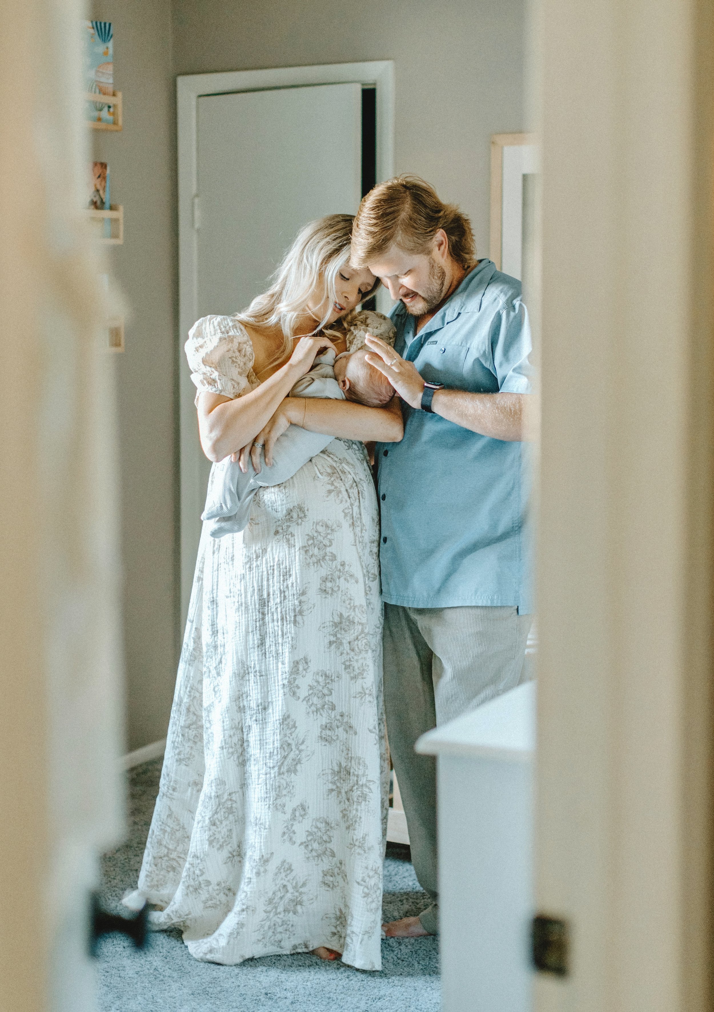 Soft morning light filters through the nursery window as this New Orleans family snuggles their newborn during an in-home lifestyle session. Captured in the comfort of their home, this photo highlights the quiet, tender moments of early parenthood—ge