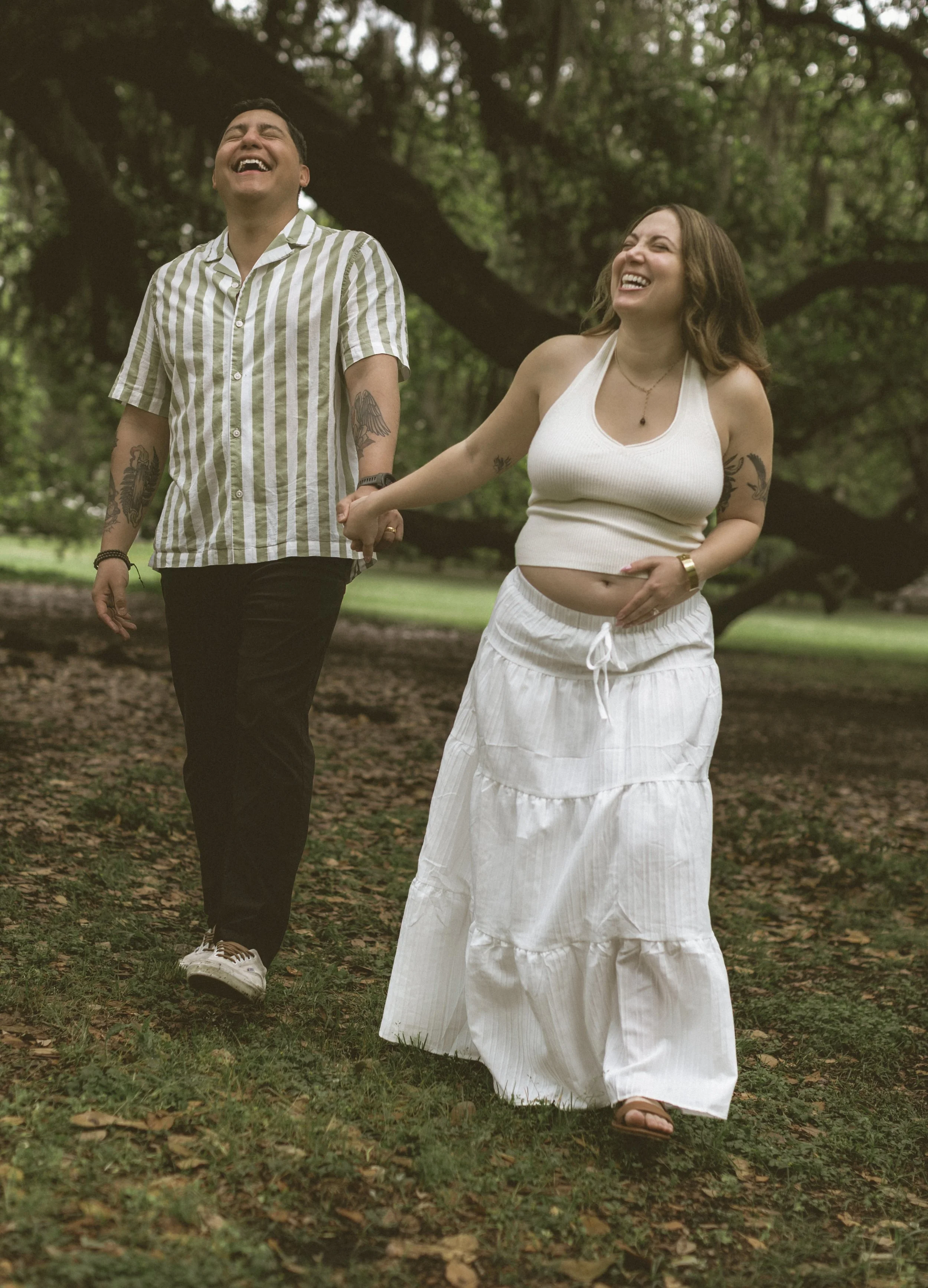 Expecting couple walking together through Audubon Park in New Orleans.