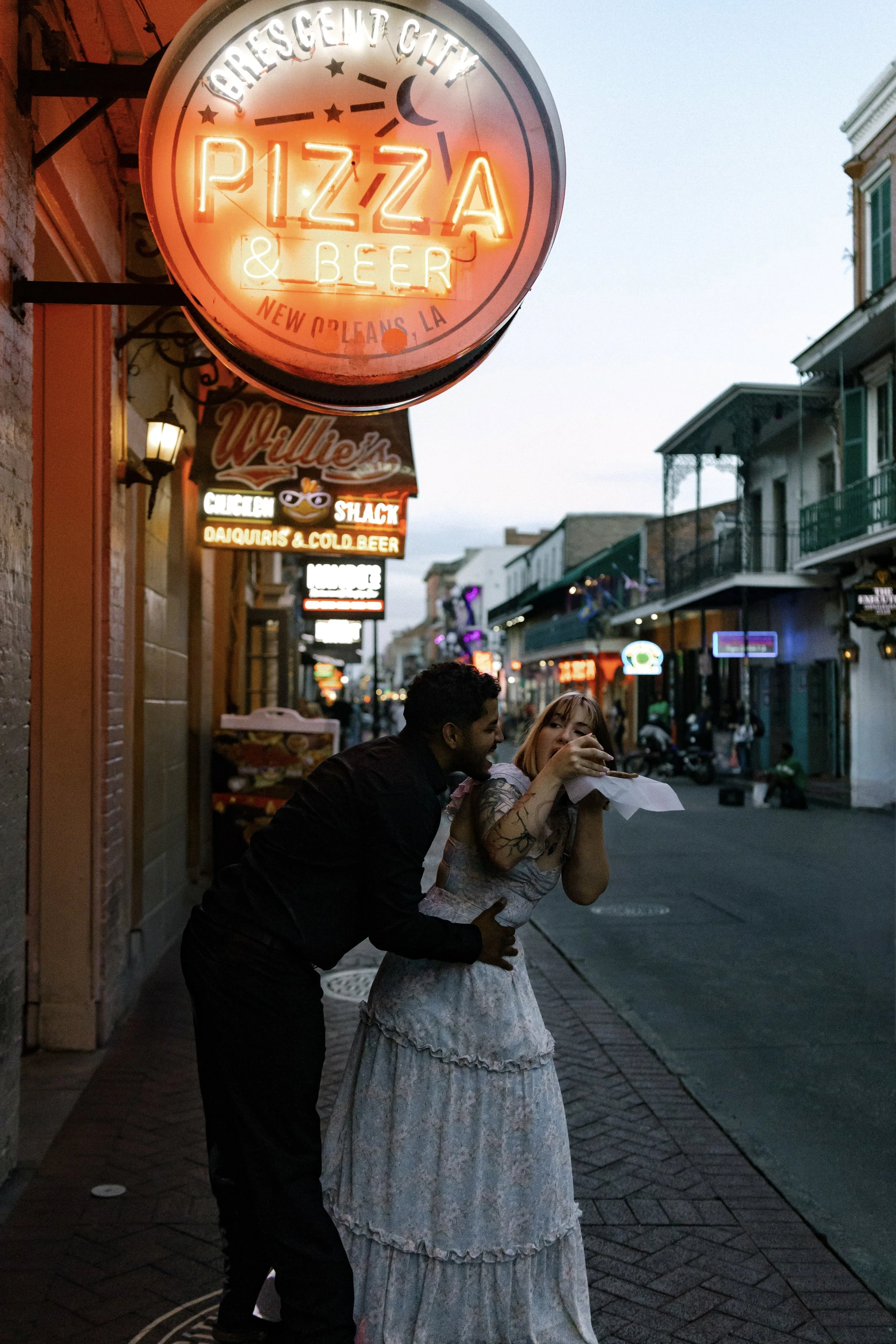 Couple sharing a slice of pizza in the French Quarter during session. 