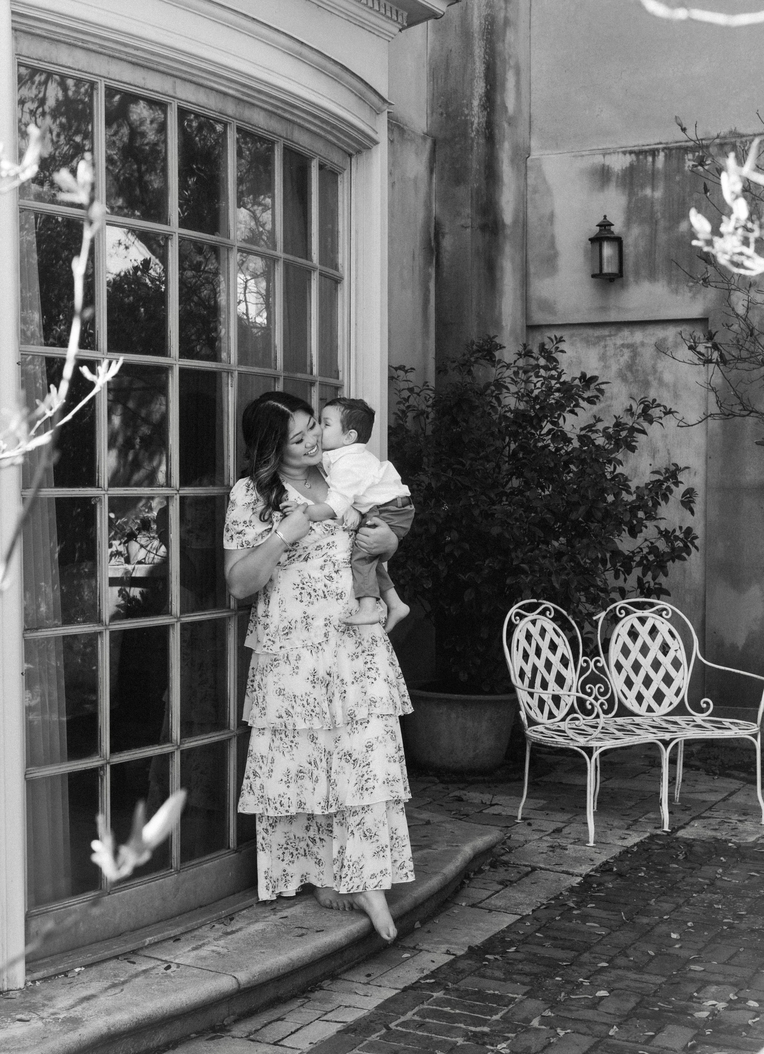 Close-up of a mom embracing her child under the oaks at Longue Vue Gardens in Metairie.