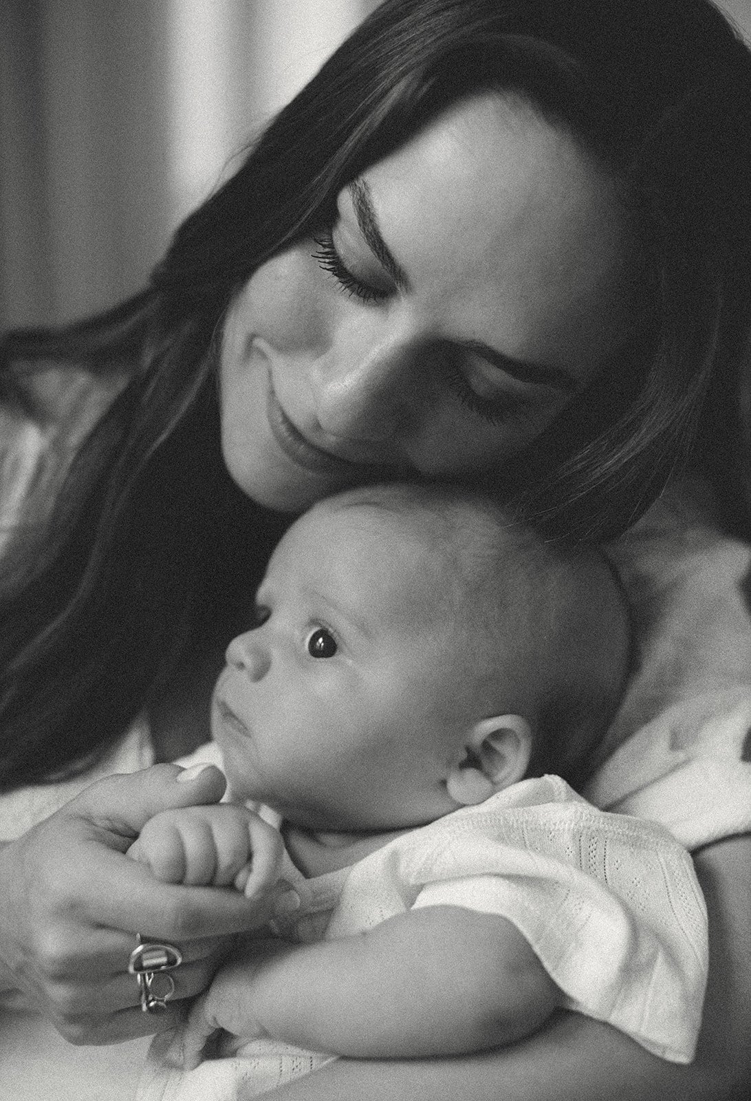 Lifestyle newborn portrait of a mother cuddling her baby inside their New Orleans home during an in-home photography session.
