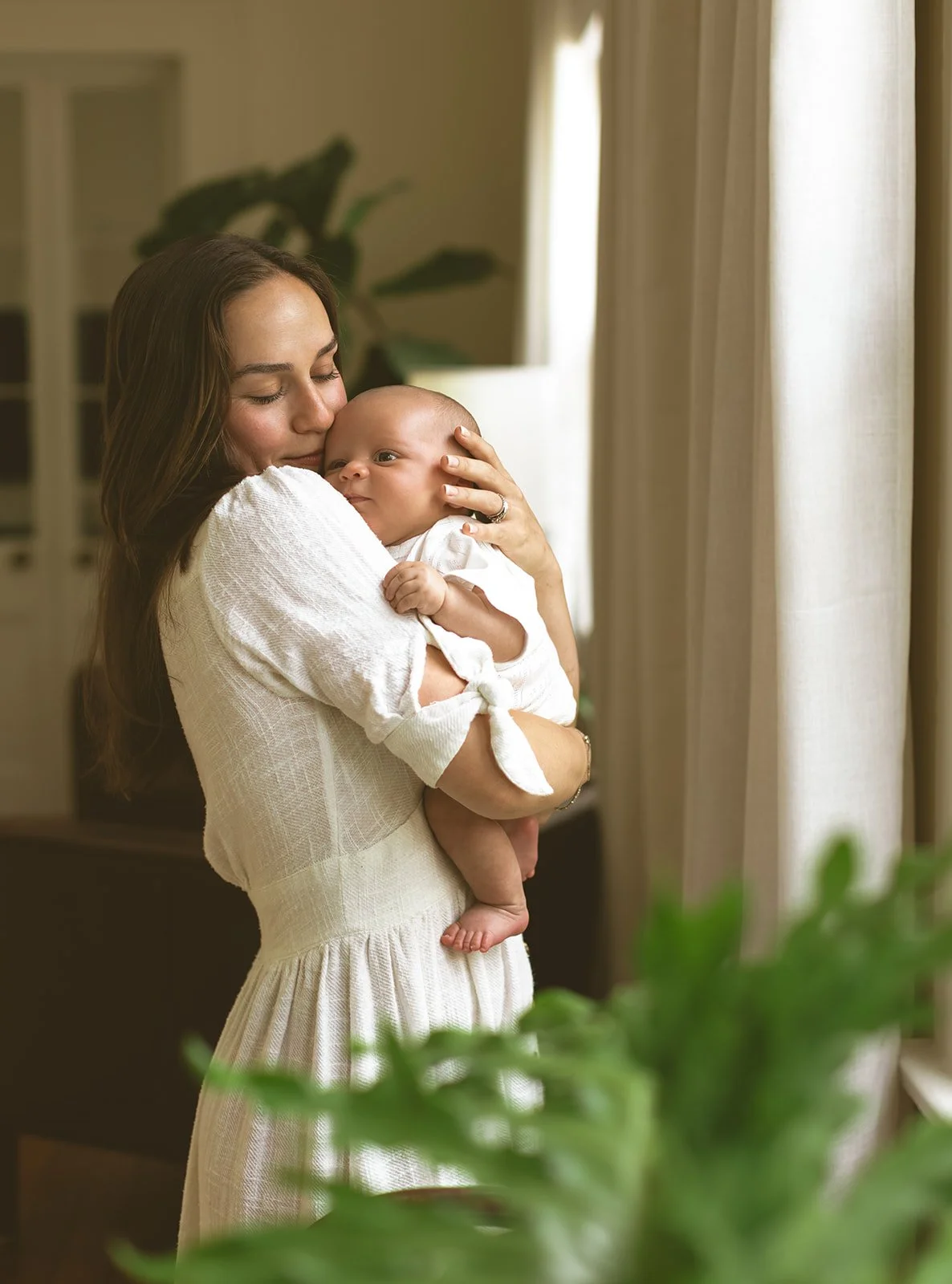 Young family sharing quiet moments together during an in-home newborn photography session in New Orleans.